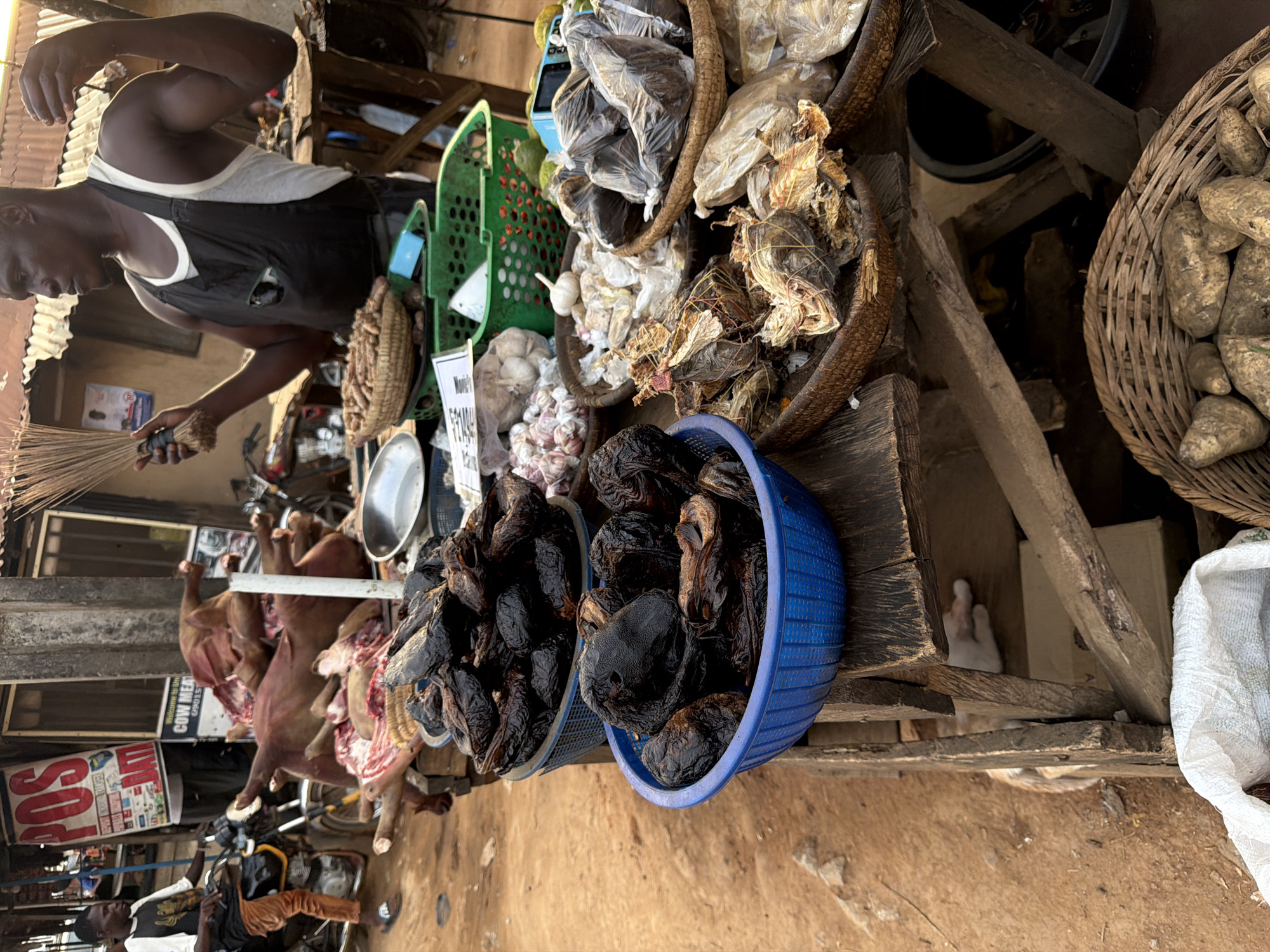 Man sweeps near meat vendors at Nigerian marketplace