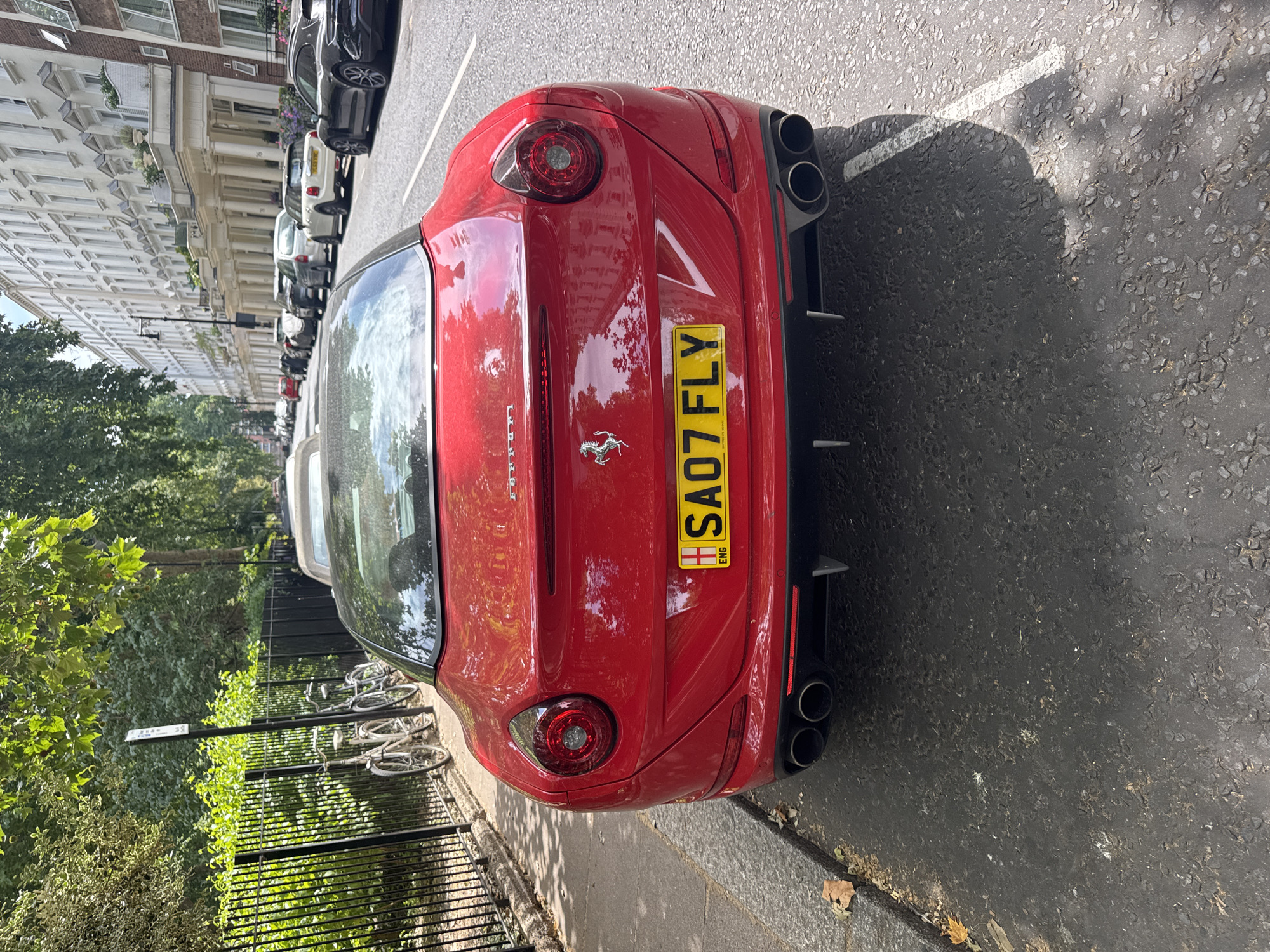 Red Ferrari California parked on a London terraced street