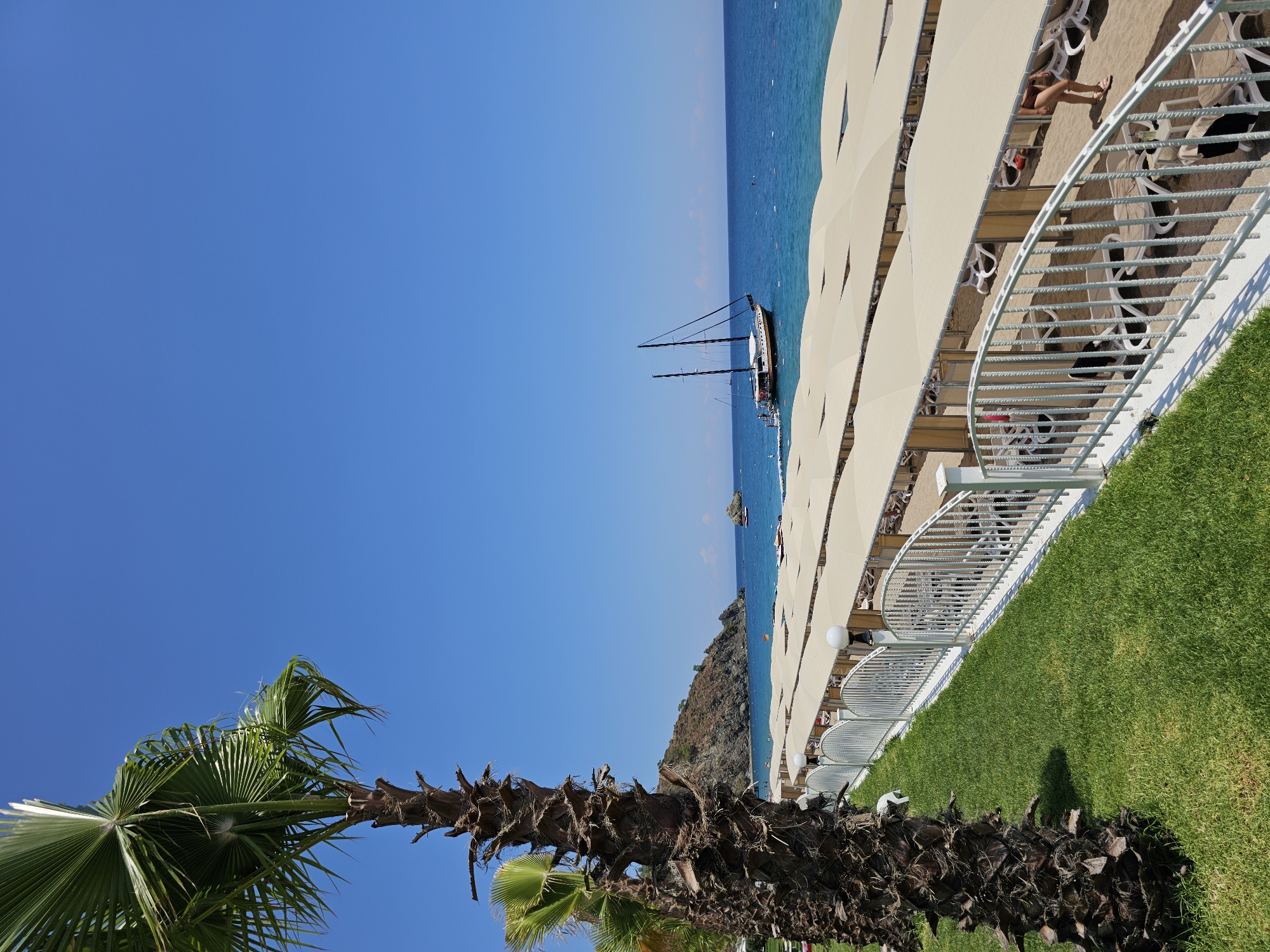 Sunny day at a beachside resort with boats offshore
