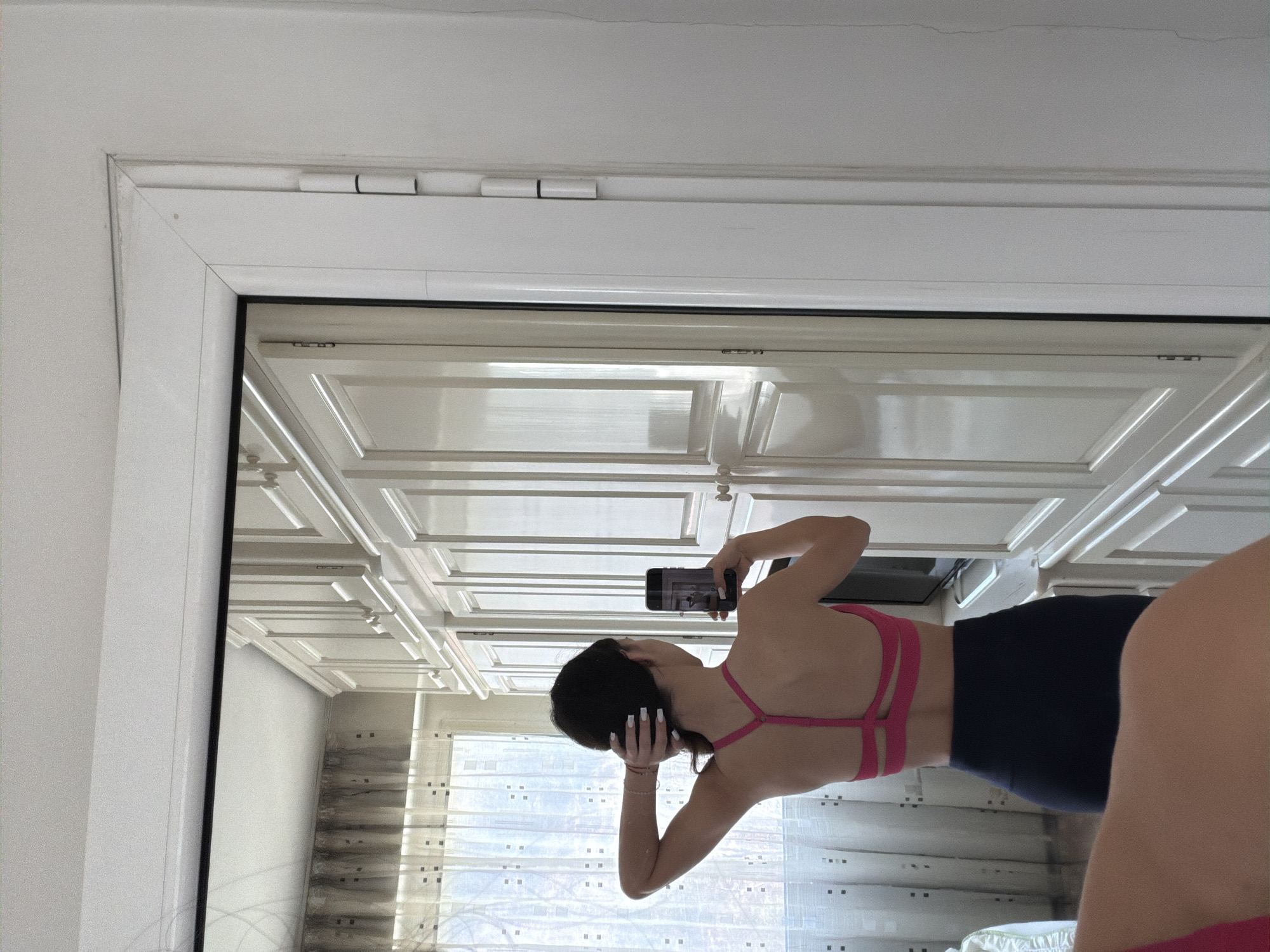 Woman takes mirror selfie in athletic wear in Gabrovo
