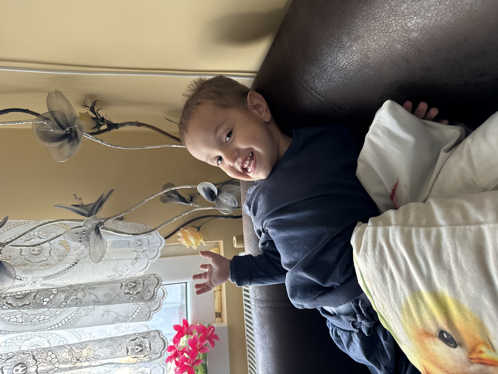 Toddler plays mobile games on couch in Belene