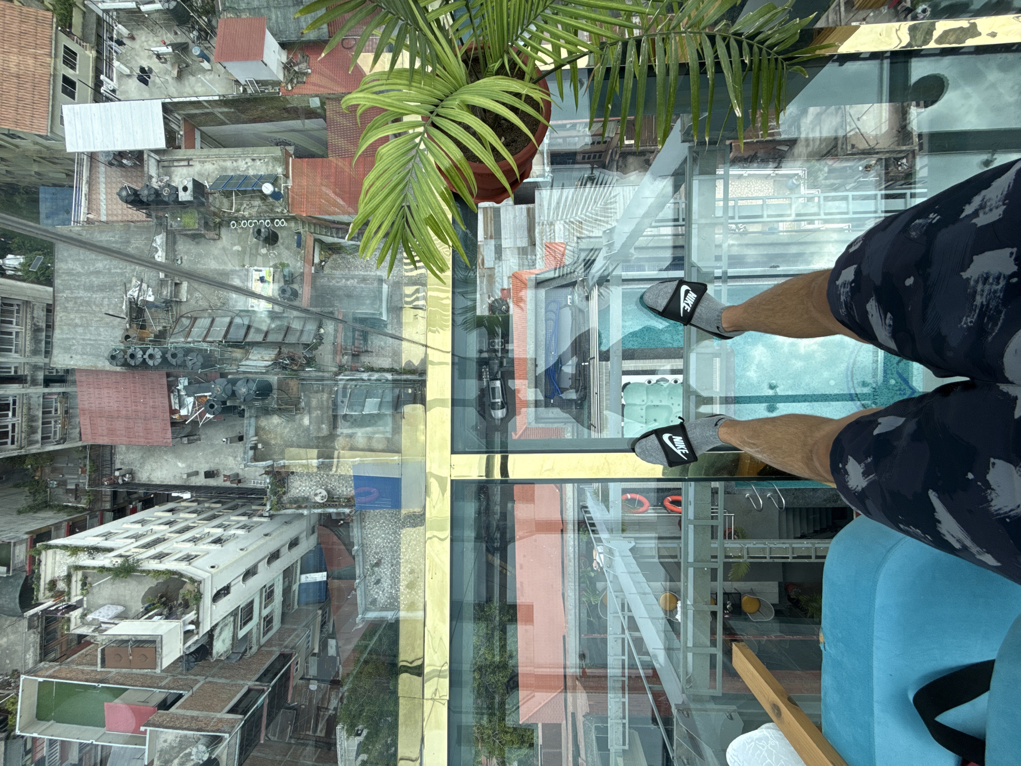 Glass-floor restaurant patron documents aerial Kathmandu cityscape views