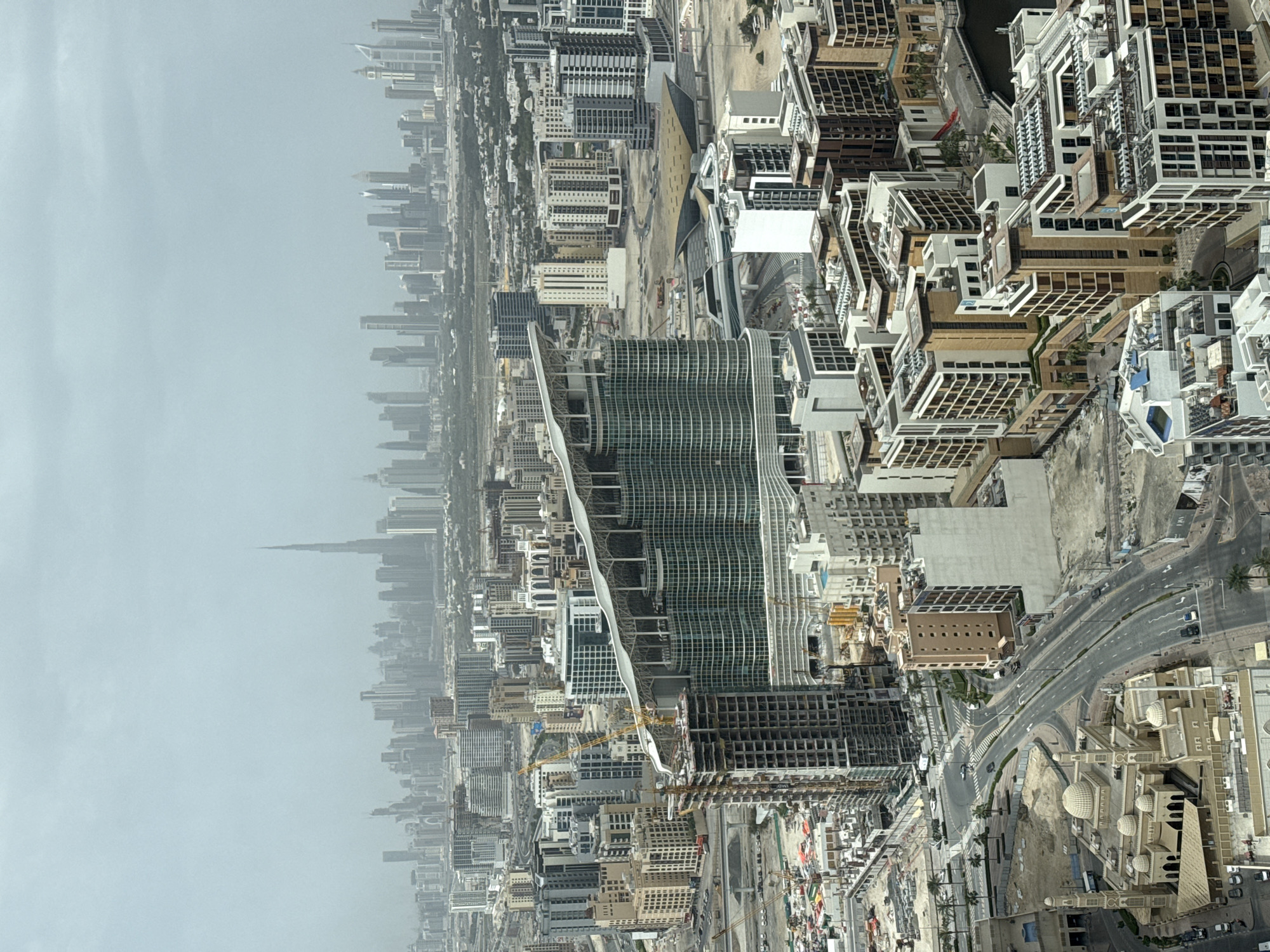 Aerial view captures dense urban skyline under hazy morning sky