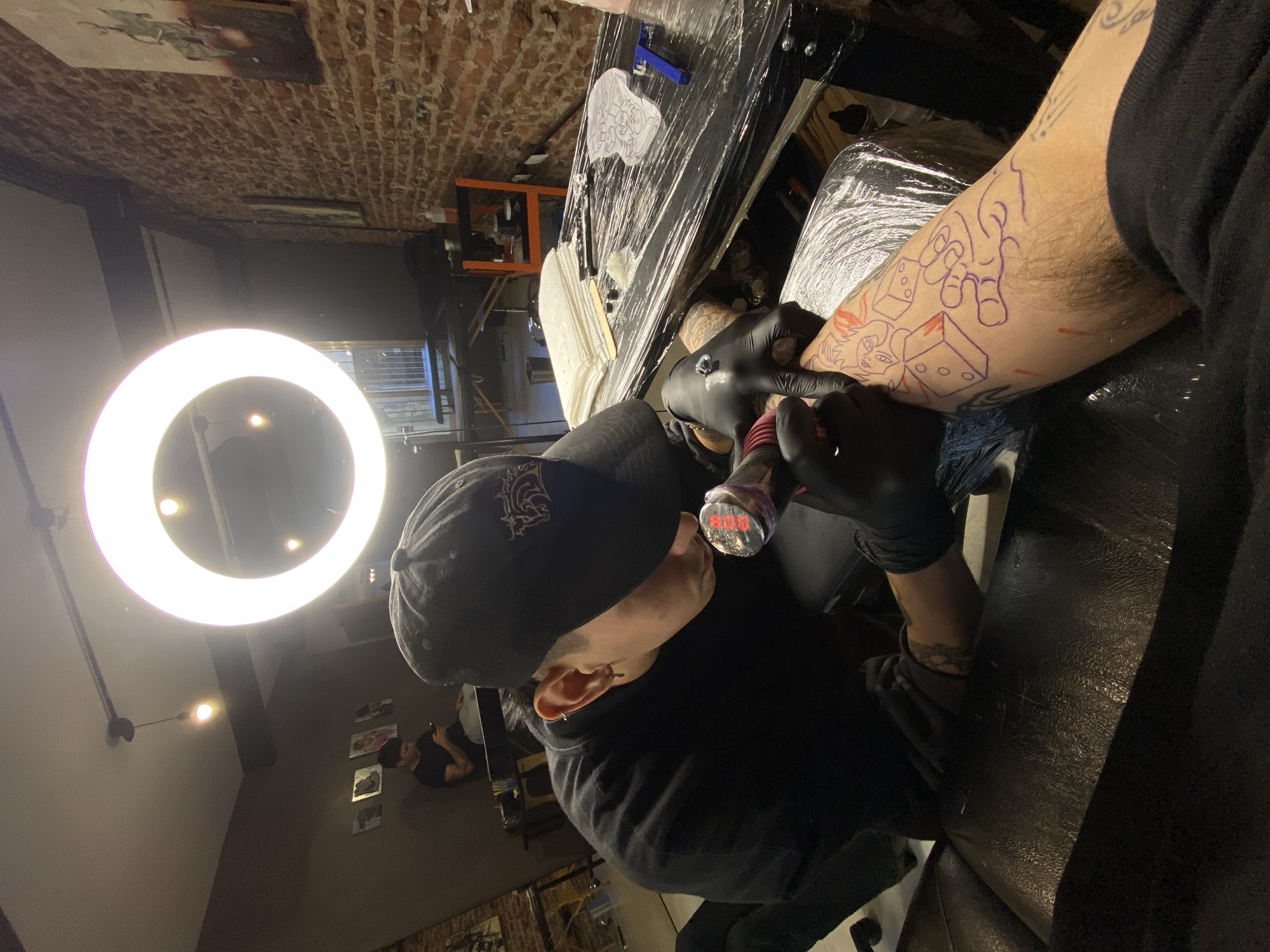 Tattoo artist works on client's forearm in Buenos Aires studio