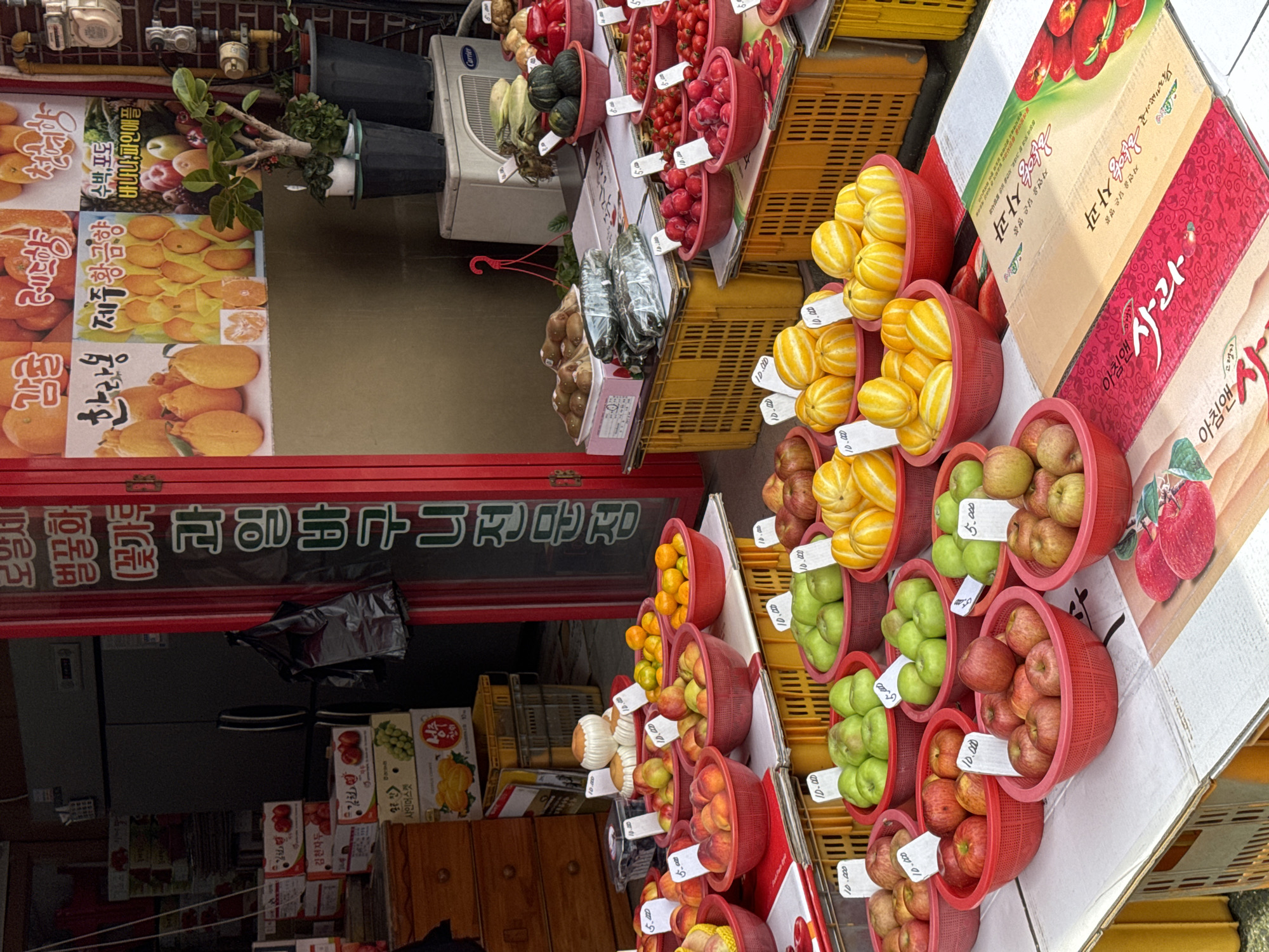 Fruit stands, flower shops, and street traffic in Jeju City