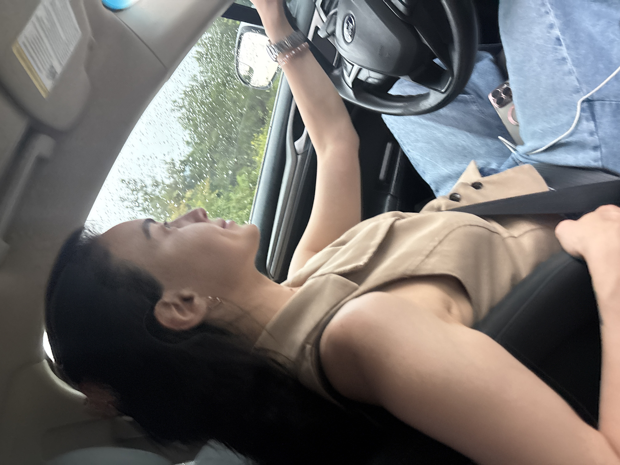 Woman drives through rainy Tbilisi on overcast afternoon