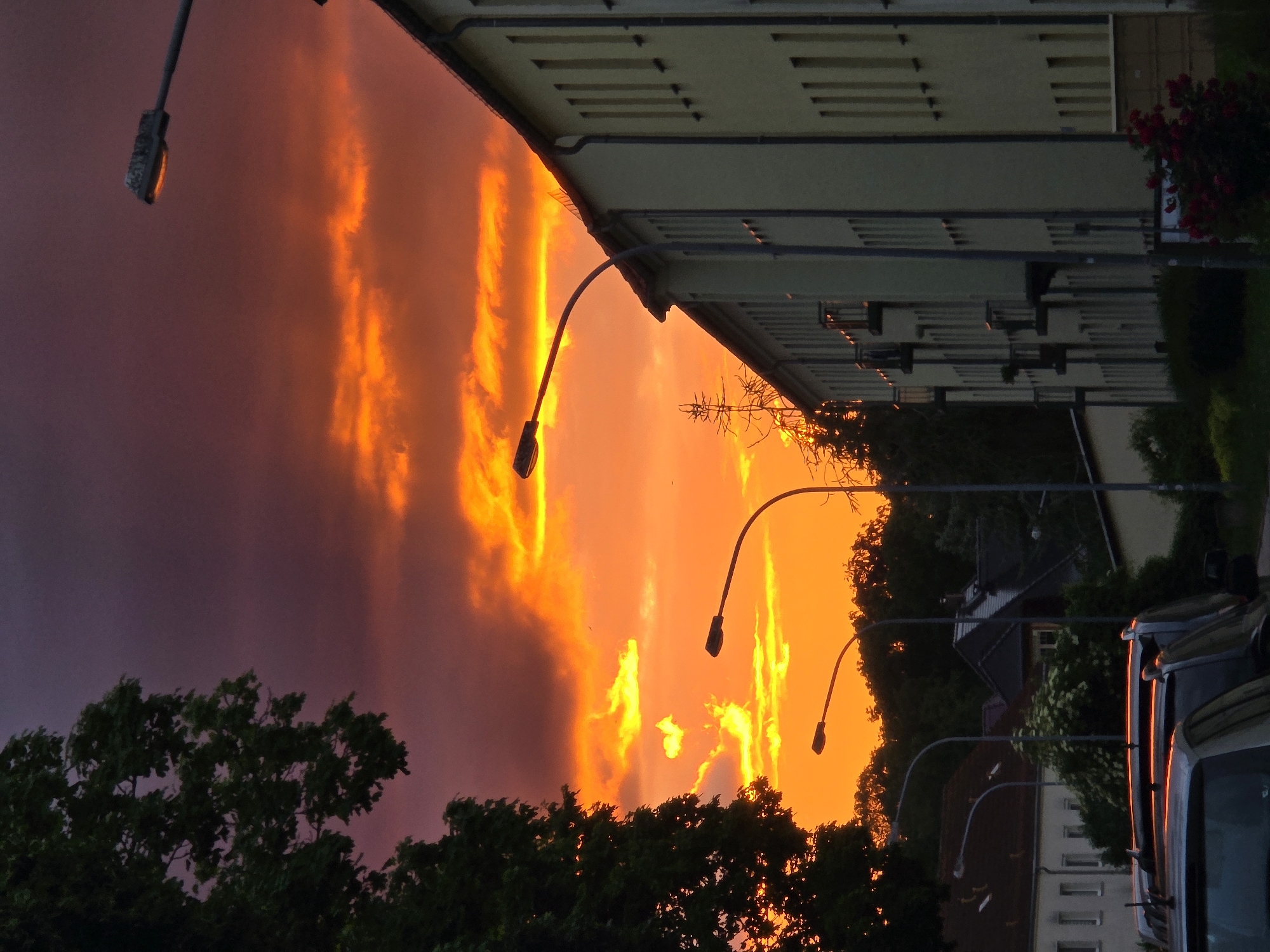 Dramatic purple sky observed over residential street during twilight