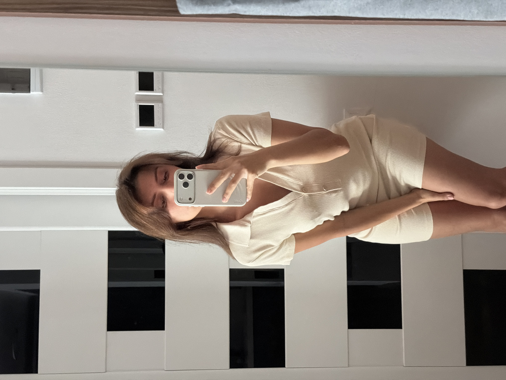 Mirror selfie session in a Batumi room, cream polo dress