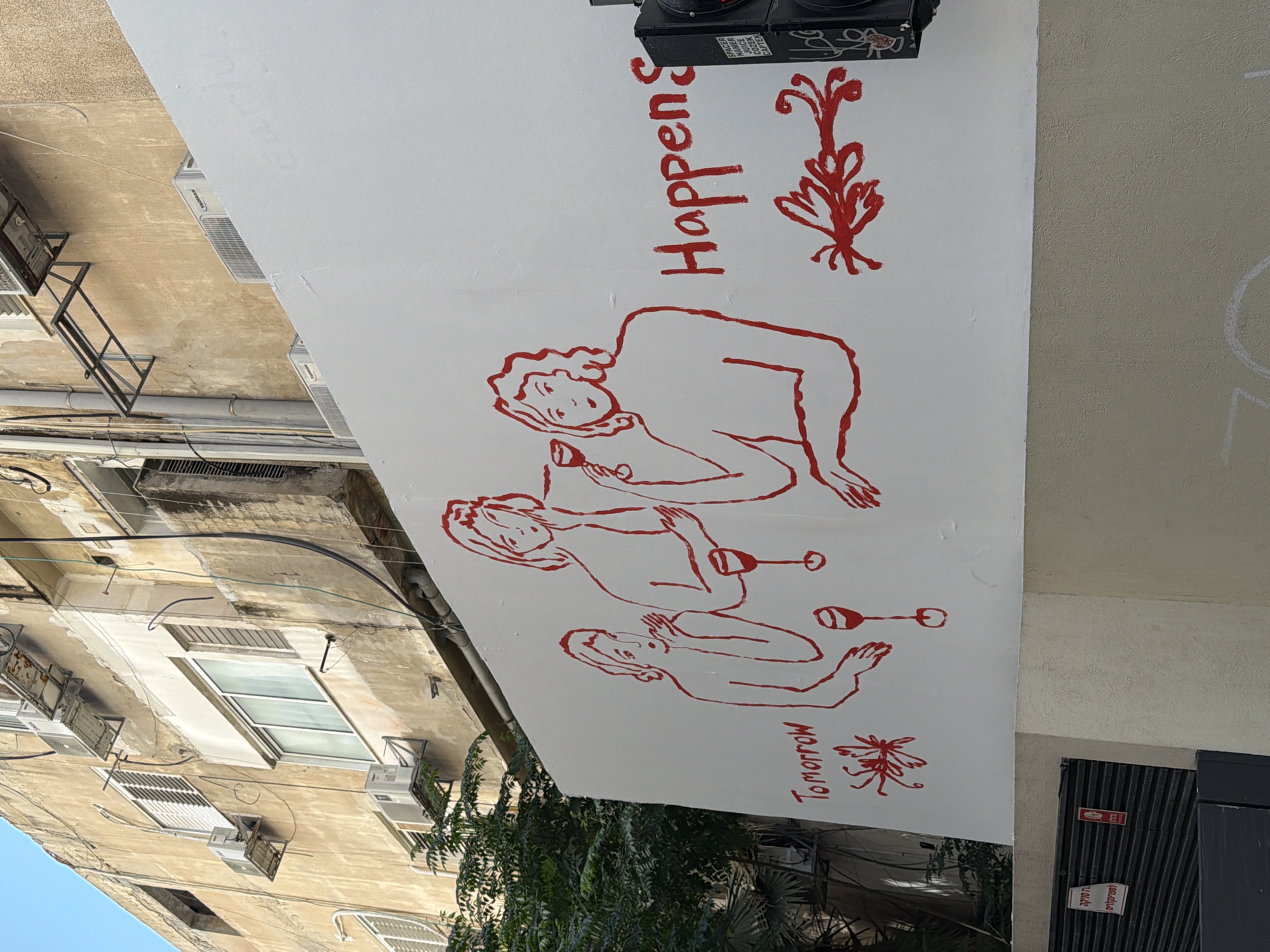 Red street mural in Tel Aviv pairs intimate figures with 'Tomorrow'