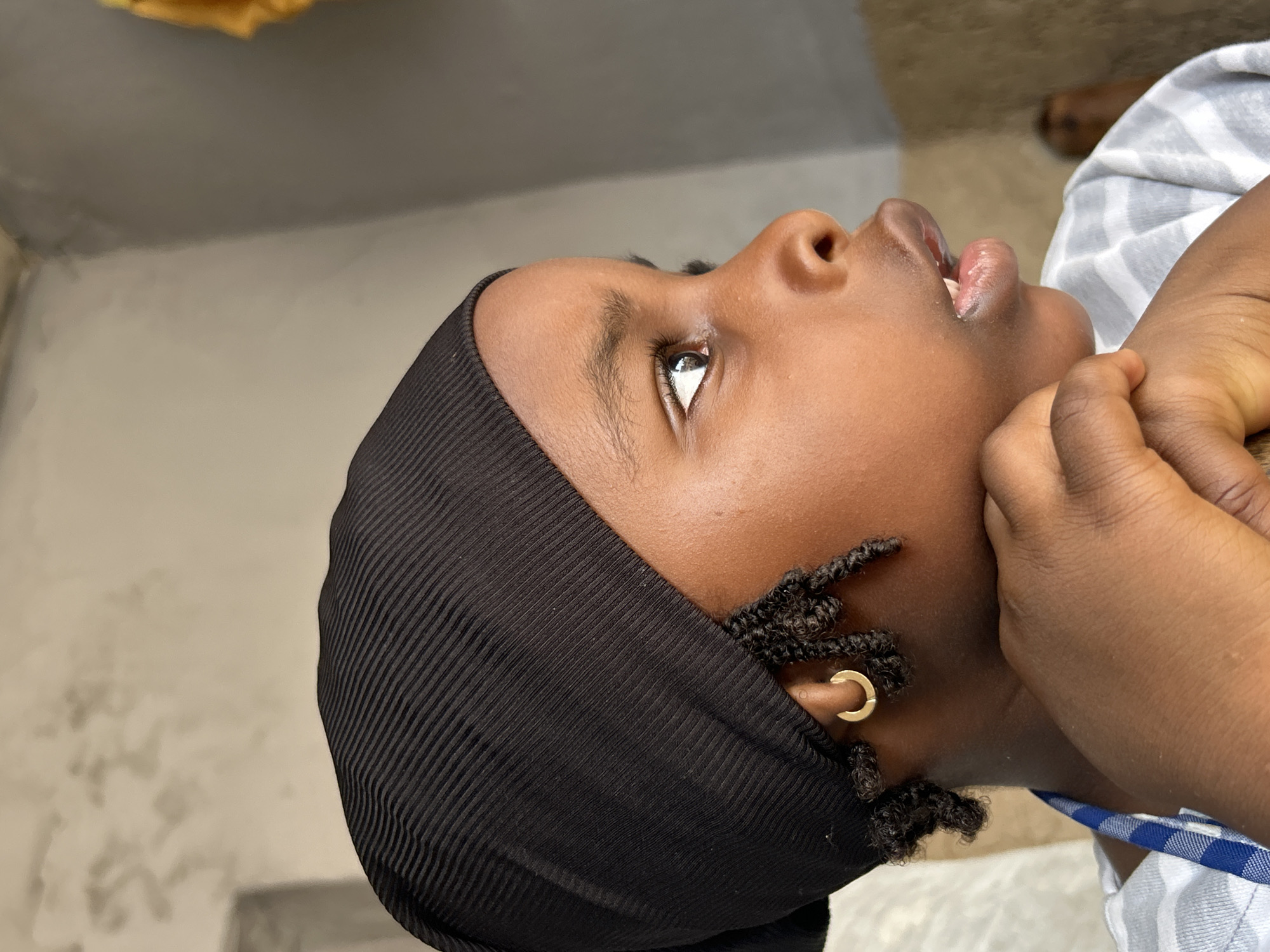 Child uses traditional mortar and pestle in Jos, Nigeria