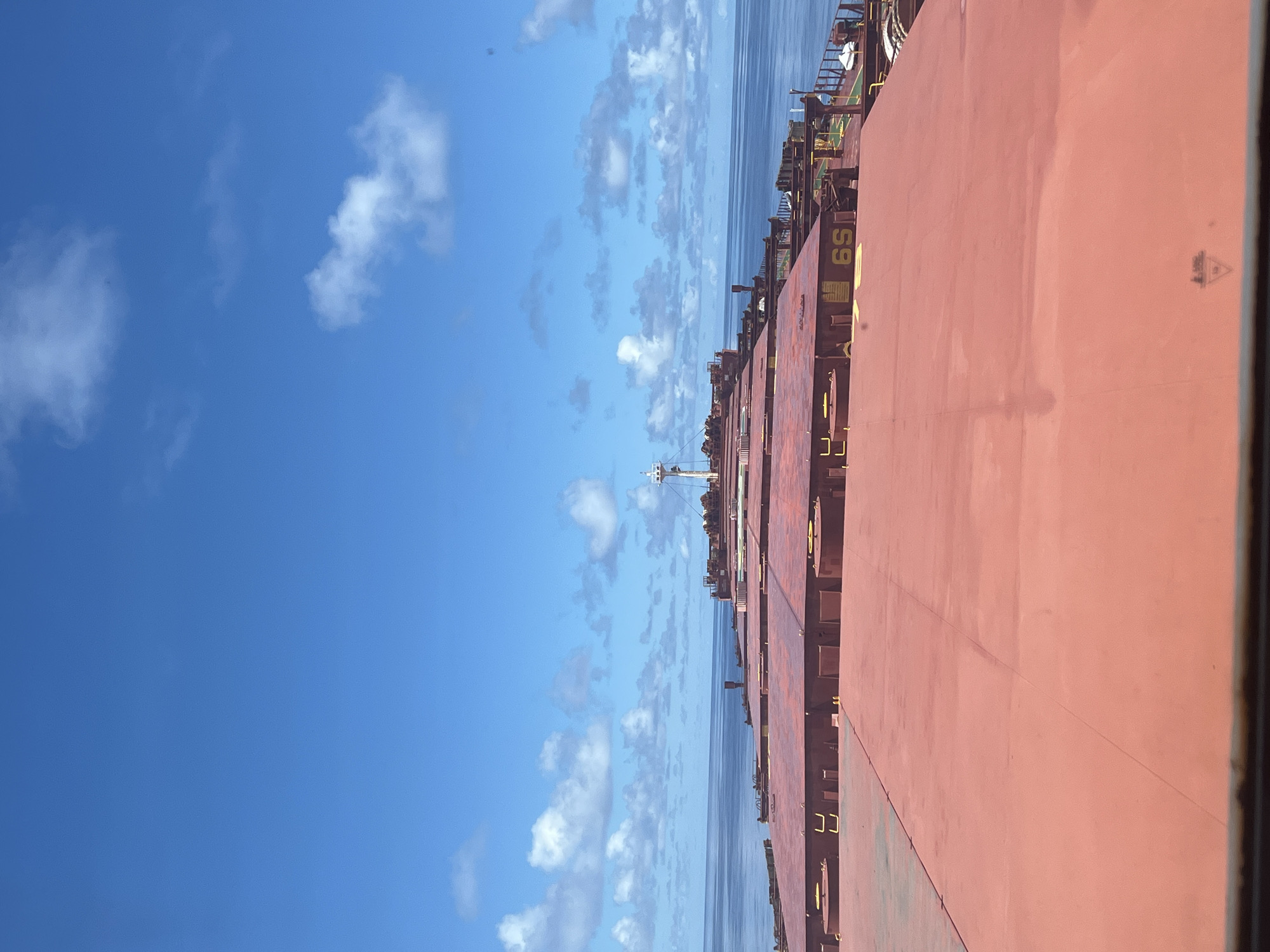 Bulk carrier at sea, red hatches across the deck