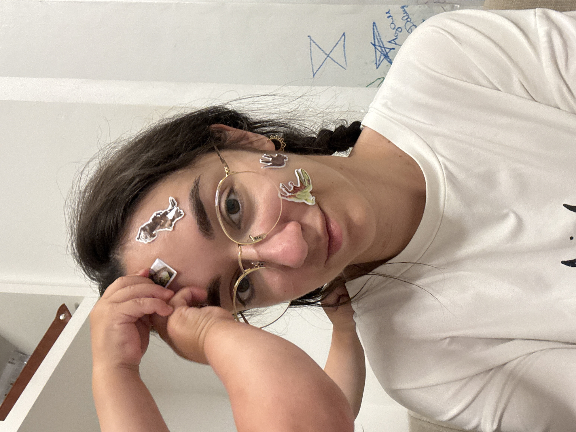 Woman with stickers on face photographed in children's room
