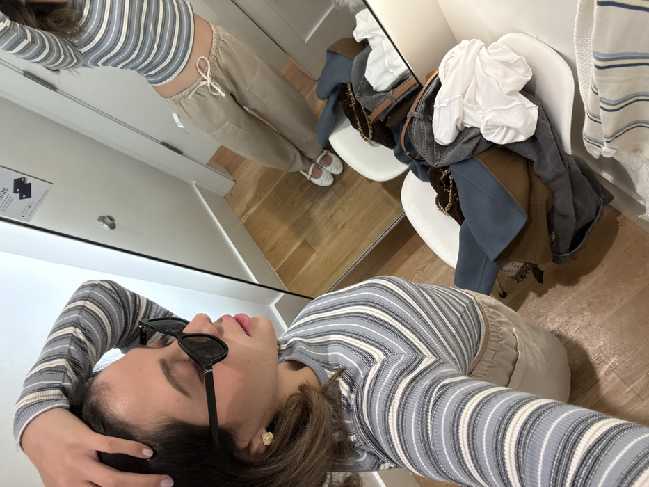 Woman tries on multiple outfits in Miami Beach fitting room