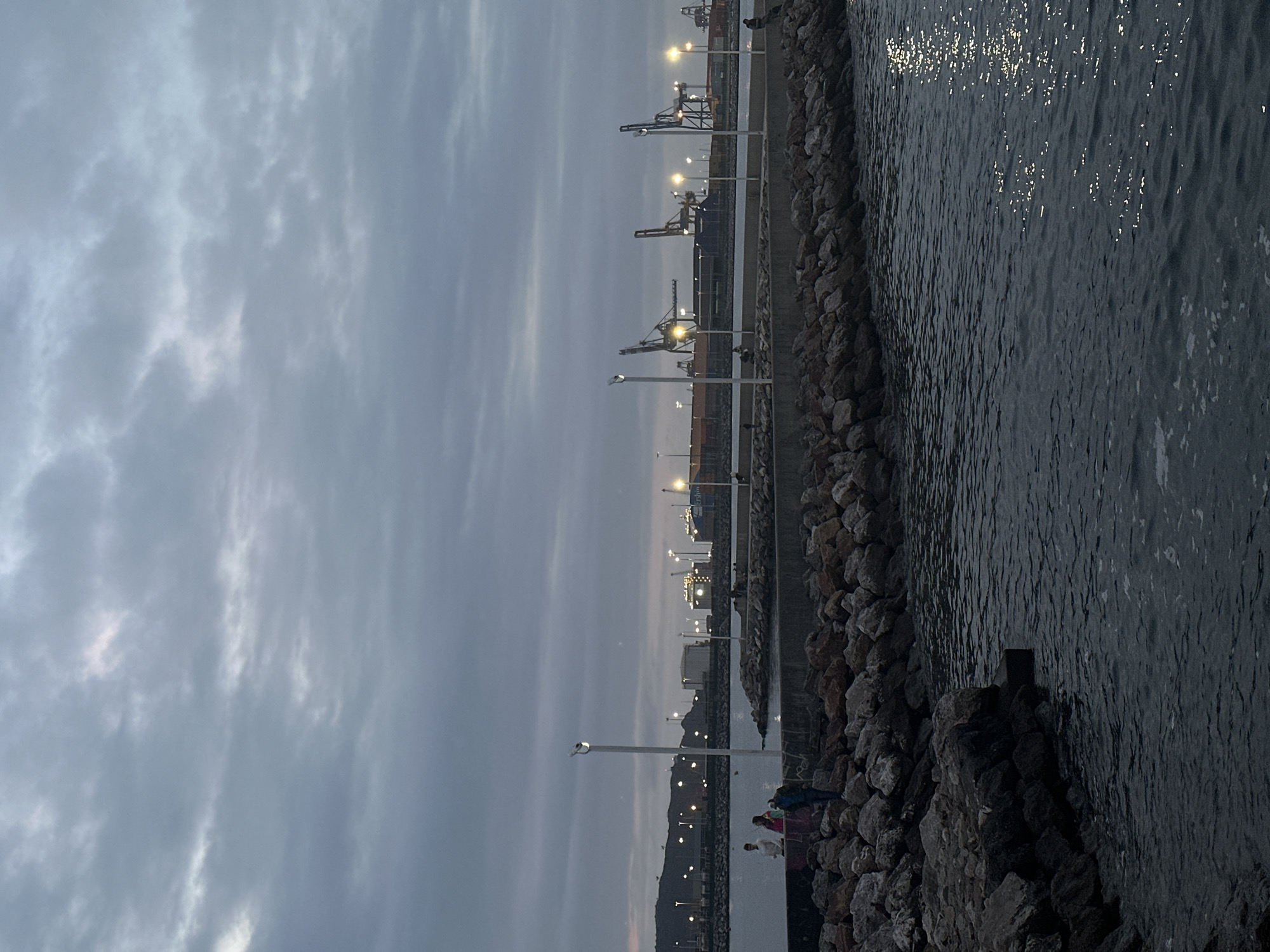 Evening scenes captured at Gijón port and beach under overcast skies