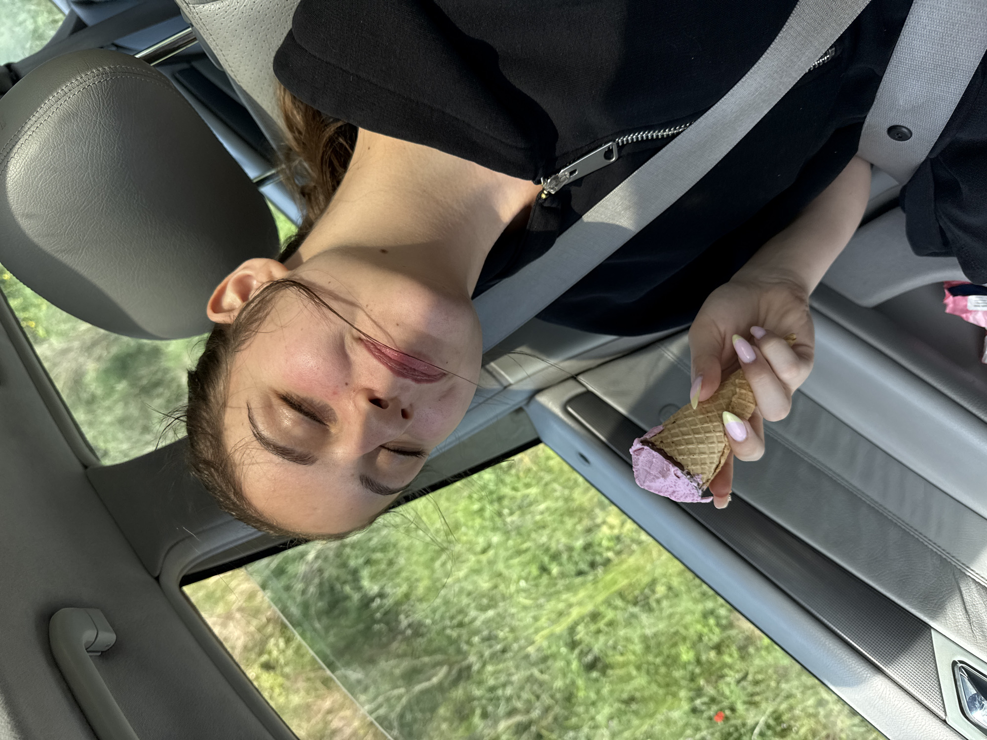 Woman enjoys ice cream in car passenger seat, Tsarevo
