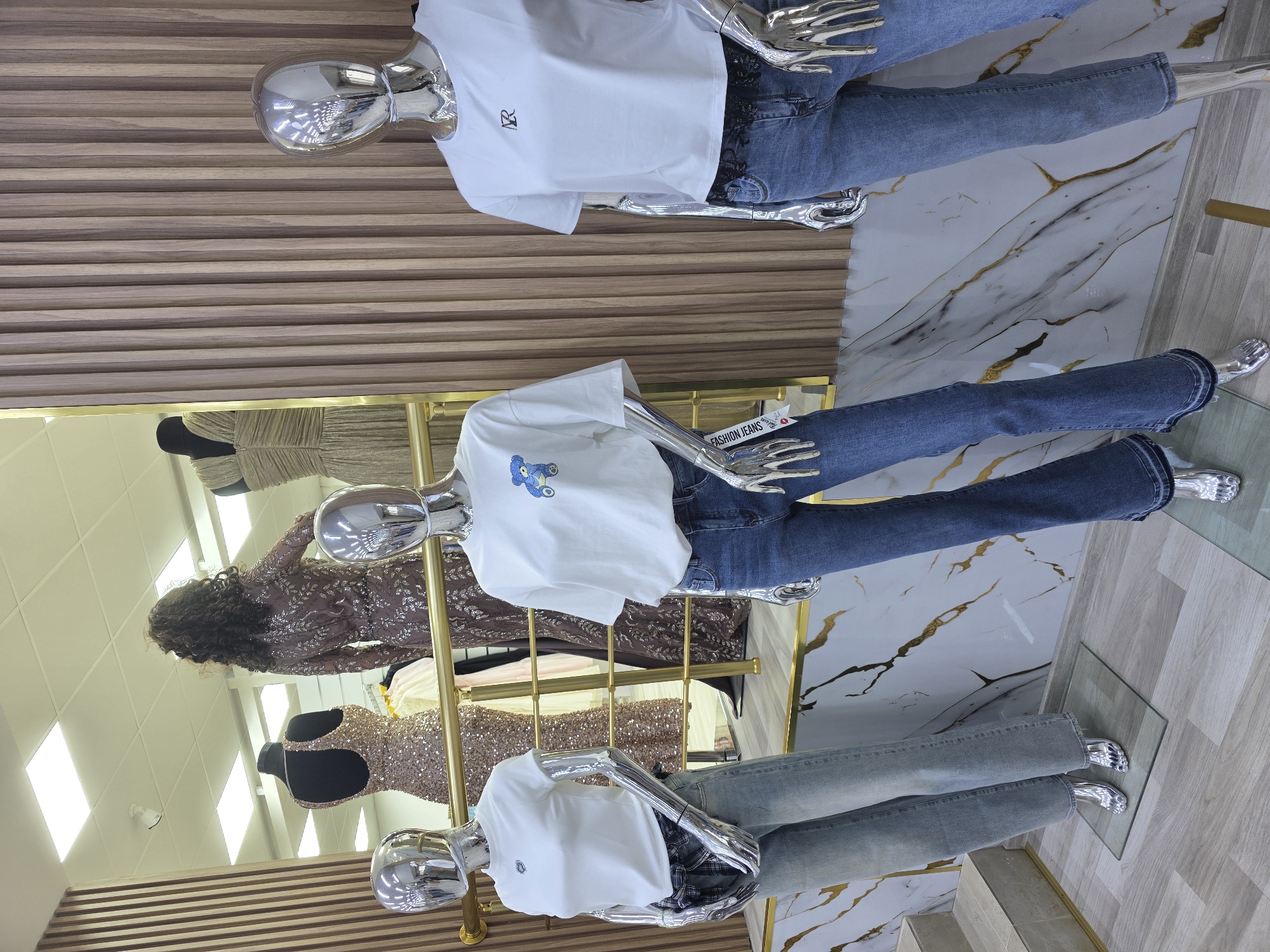 Clothing store display features mannequins in casual wear