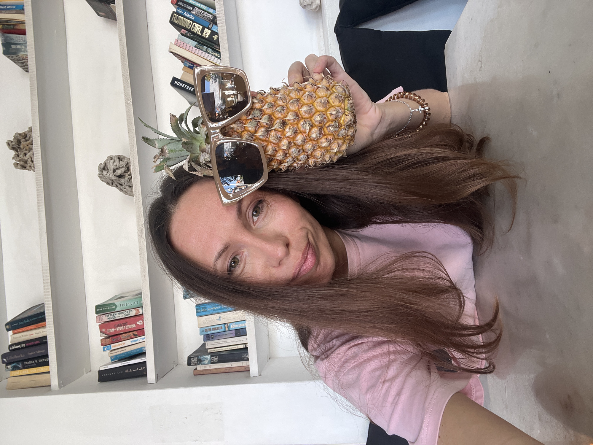 Woman poses with sunglasses-wearing pineapple in North Kuta home