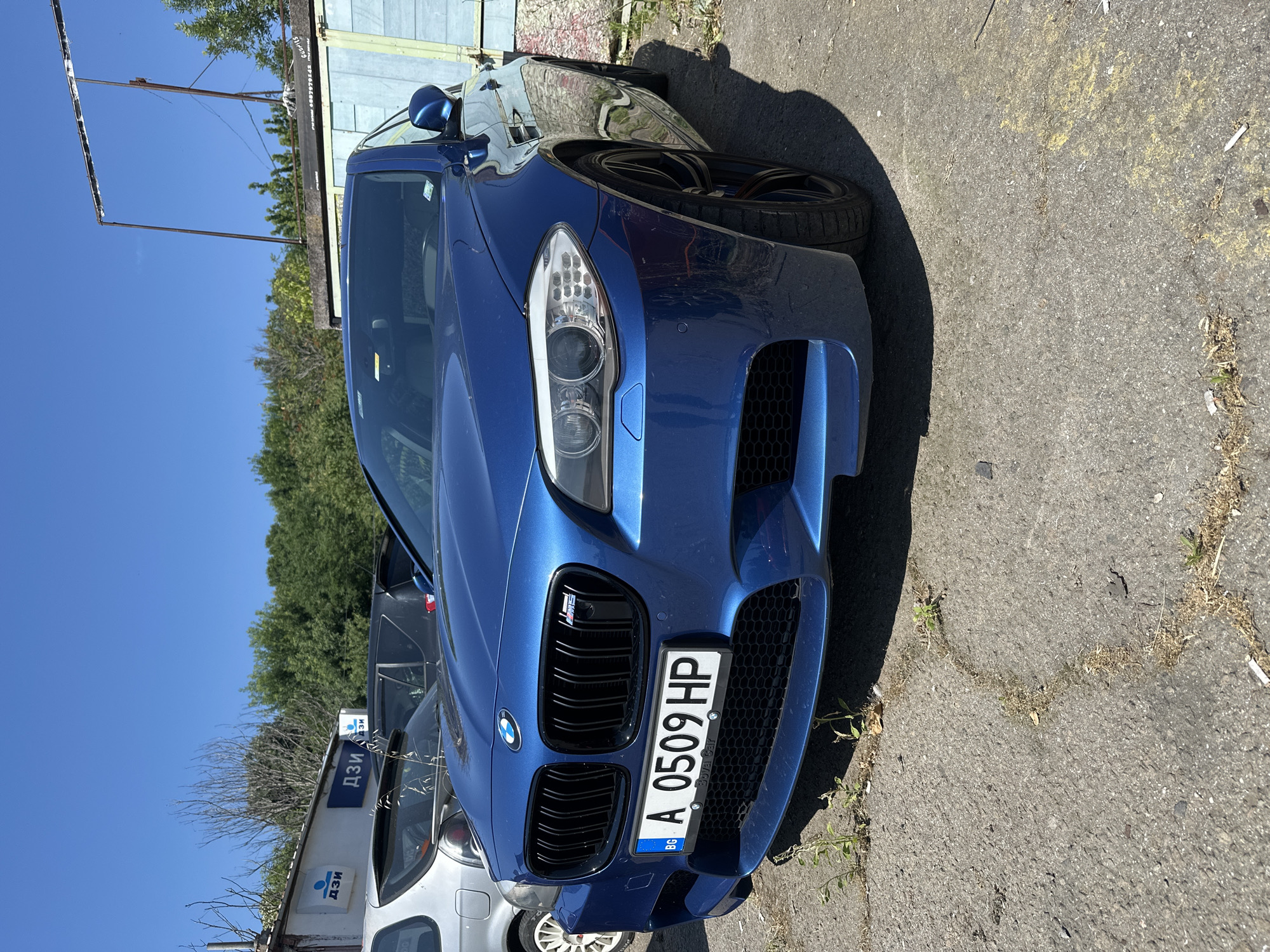 Blue BMW M5 photographed from multiple angles in outdoor lot