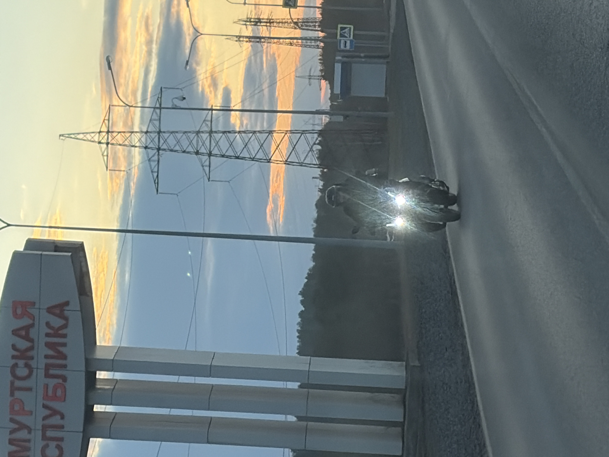 Motorcycle travels road in Chaikovsky, Russia near republic signage