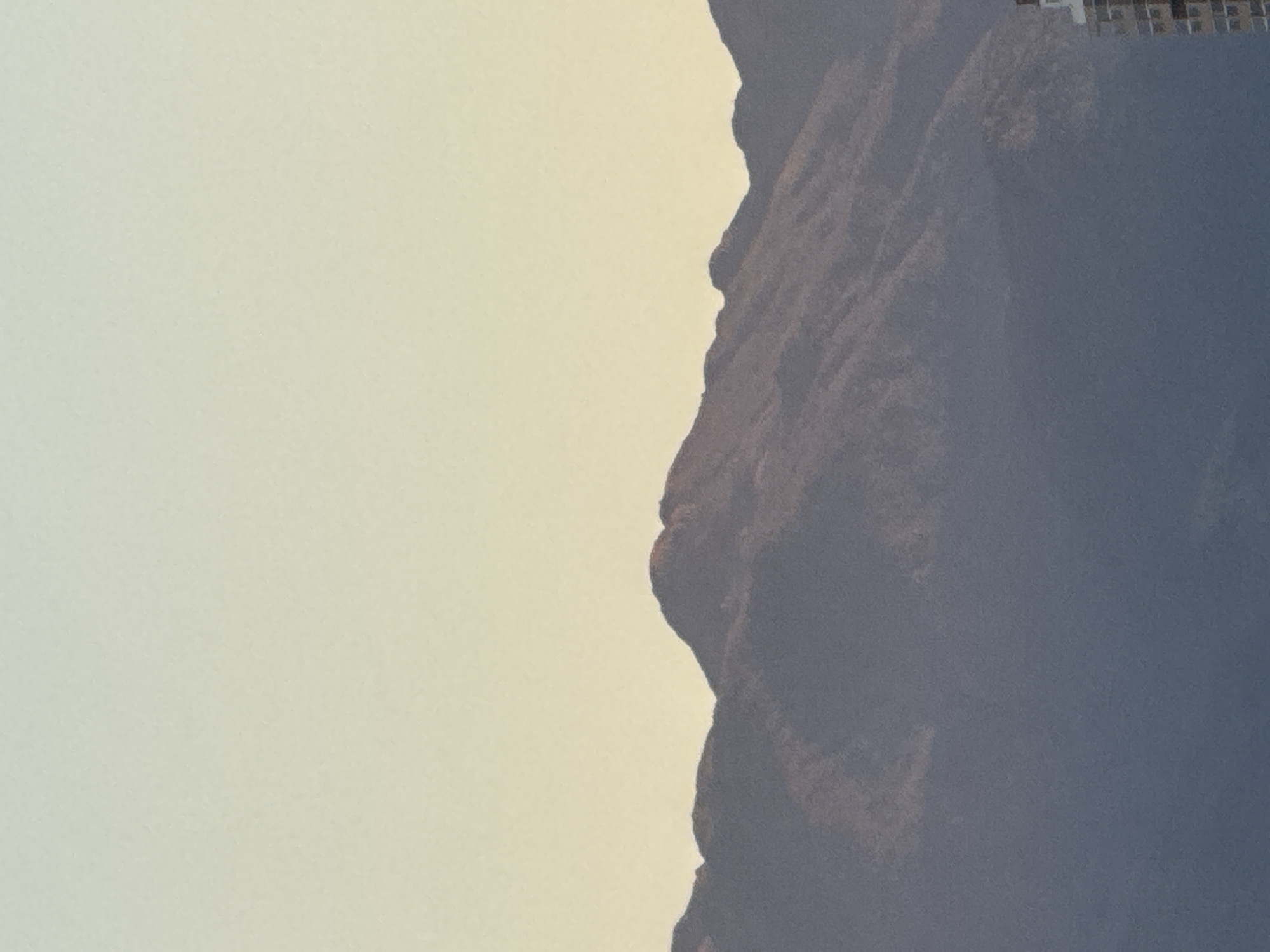 Silhouetted mountain range at dusk, warm horizon glow