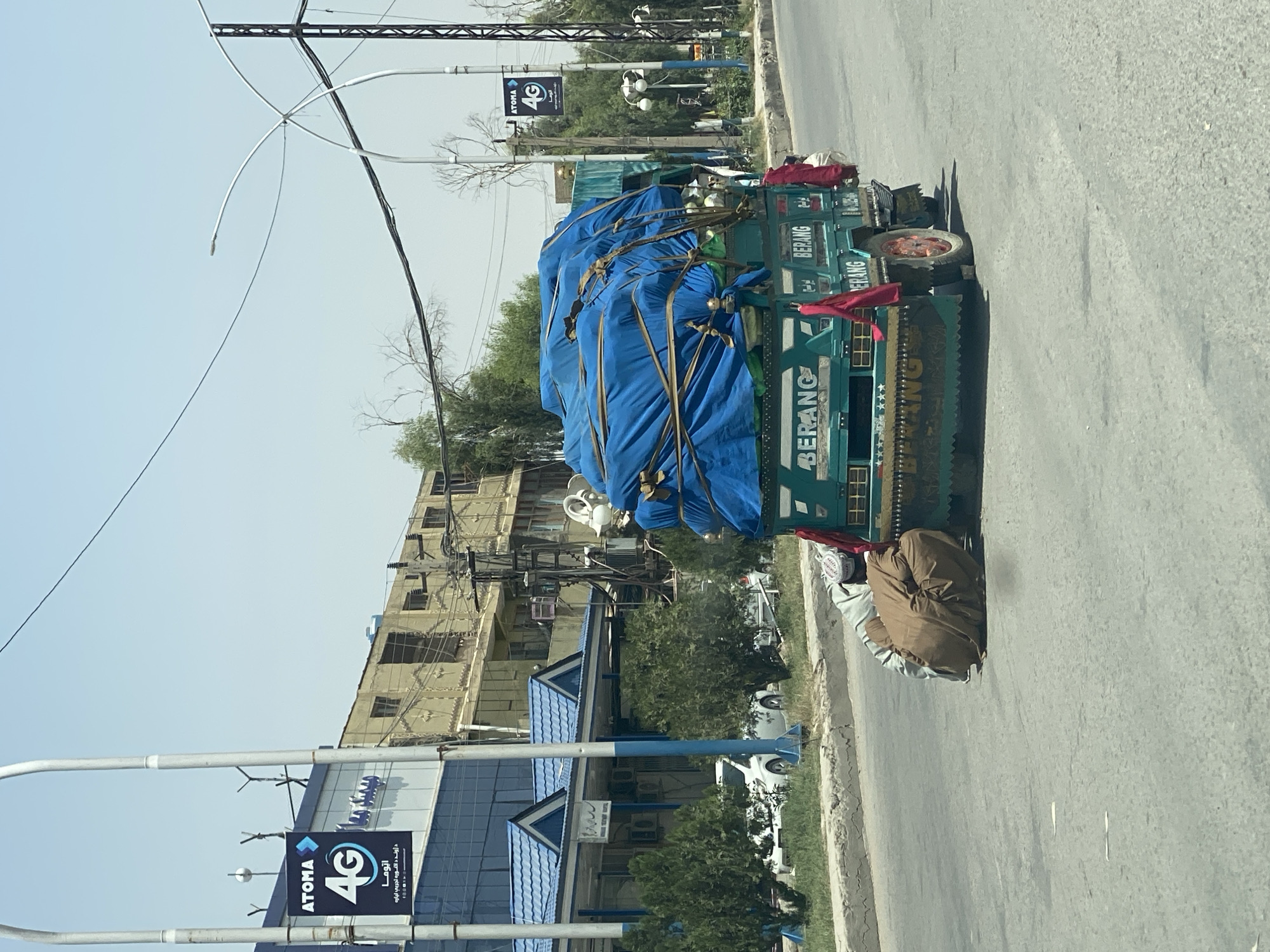 Teal cargo truck parked roadside in Kandahar, Afghanistan