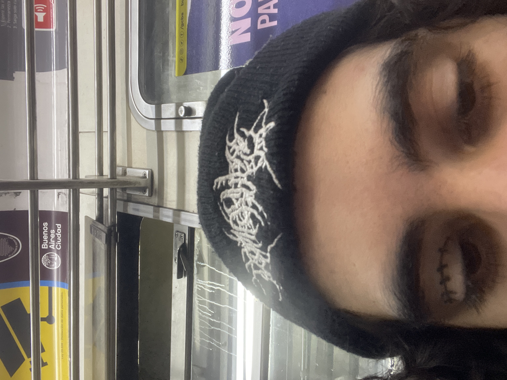 Tattooed individual photographed at Buenos Aires subway station