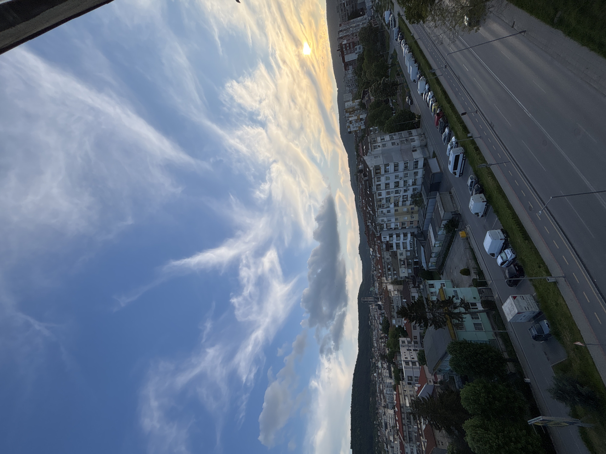 Photographer documents city sunset with DSLR camera from elevated viewpoint