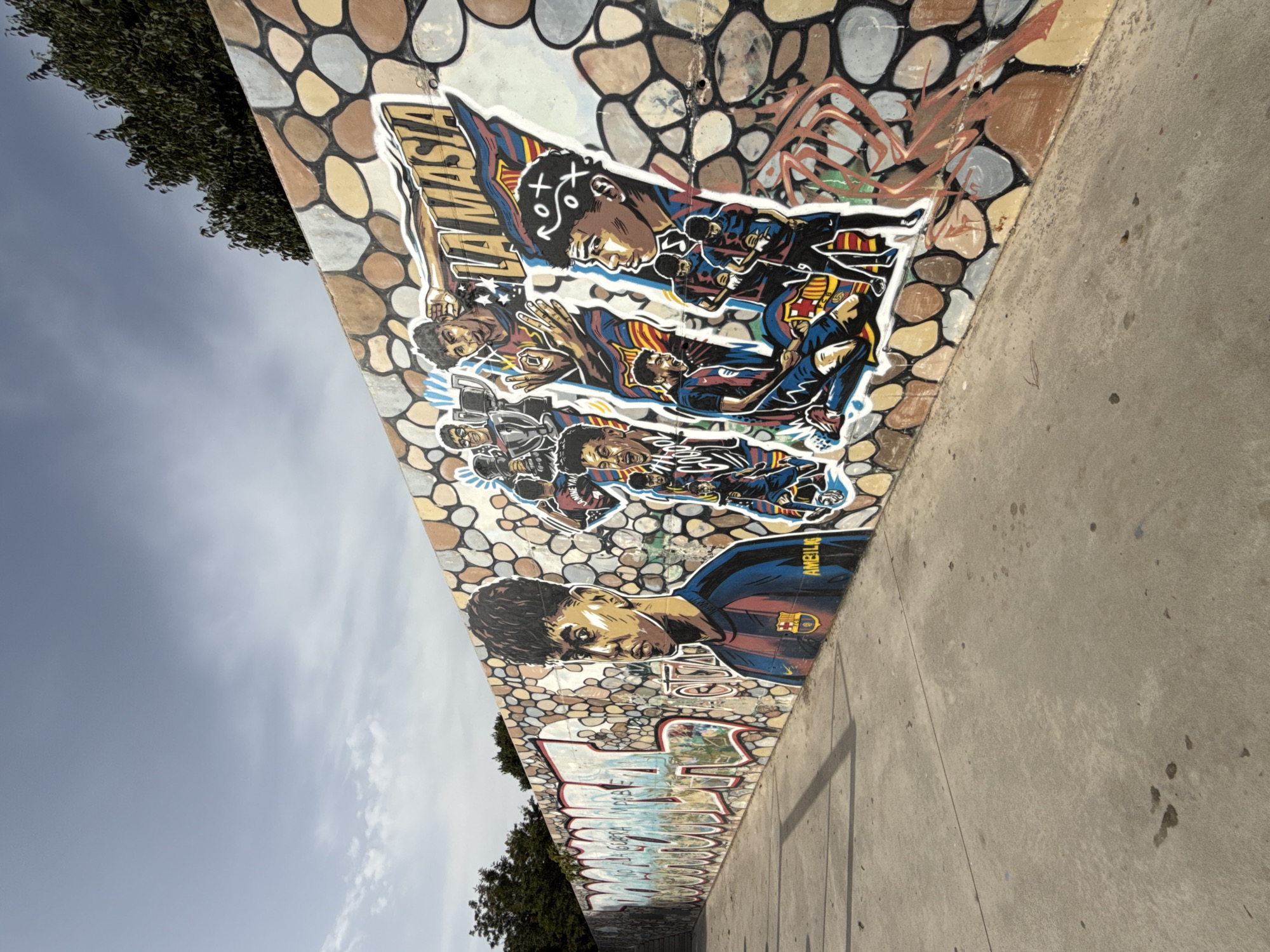 Soccer-themed graffiti mural on a mosaic wall in Mataró