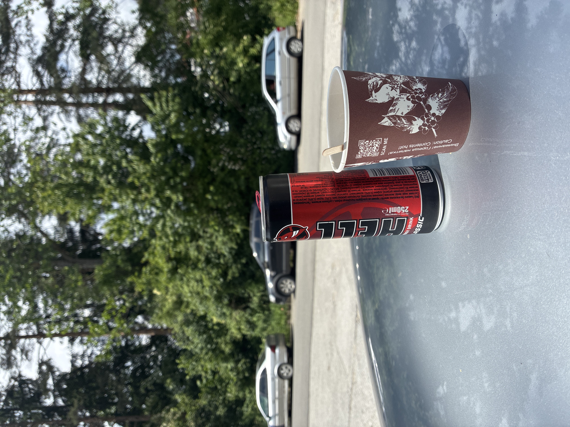 Energy drink and cup spotted on car hood in Smolyan