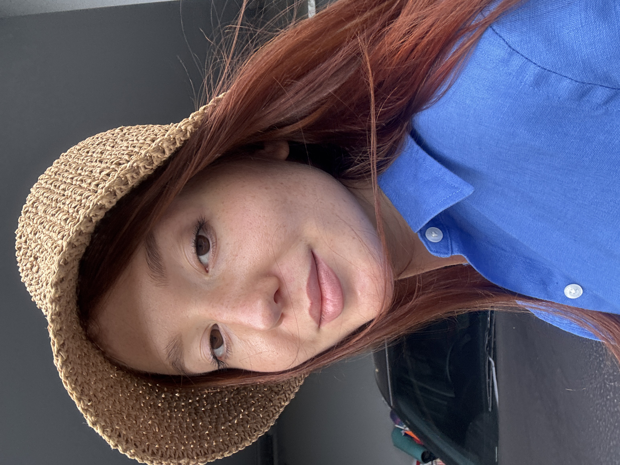 Red-haired person in straw hat observed indoors in Thailand