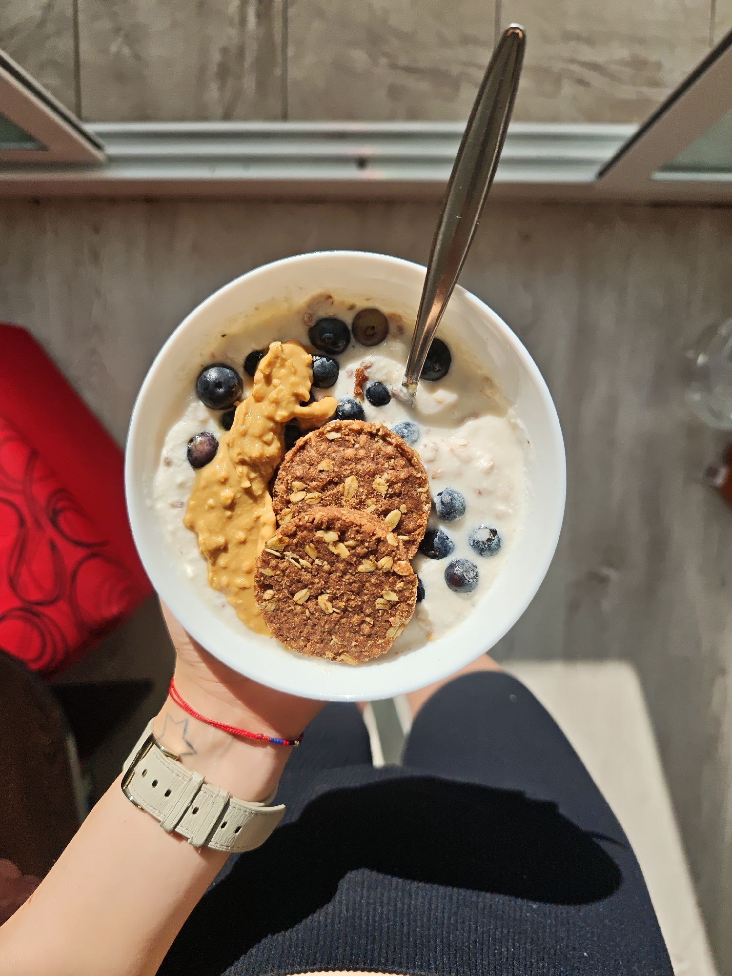 Person holds breakfast bowl with creamy meal at dawn