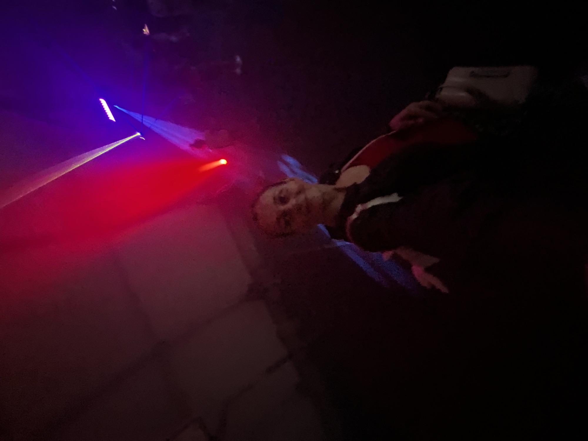 Inside a laser-lit party venue, dancing and selfies.