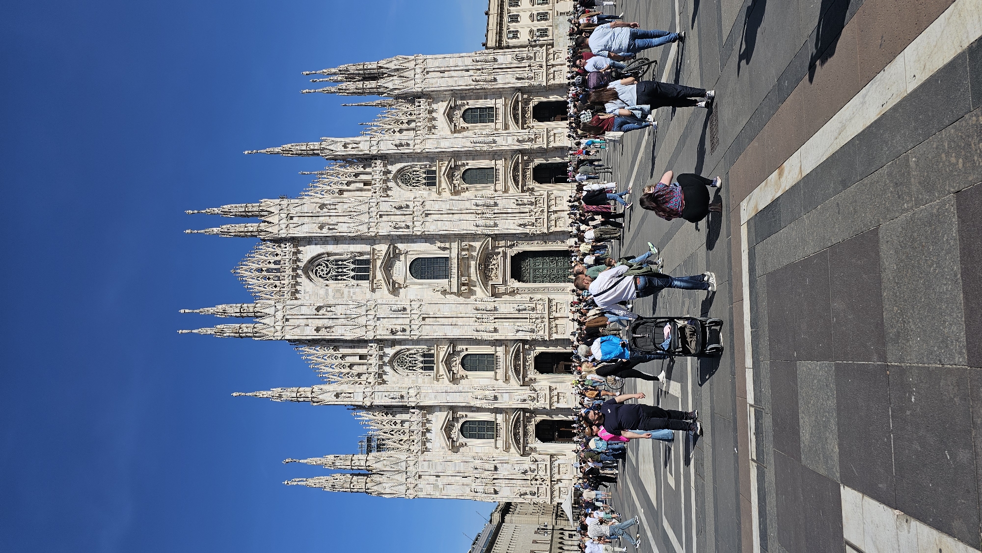Tourists gather at Milan Cathedral and Galleria on sunny afternoon