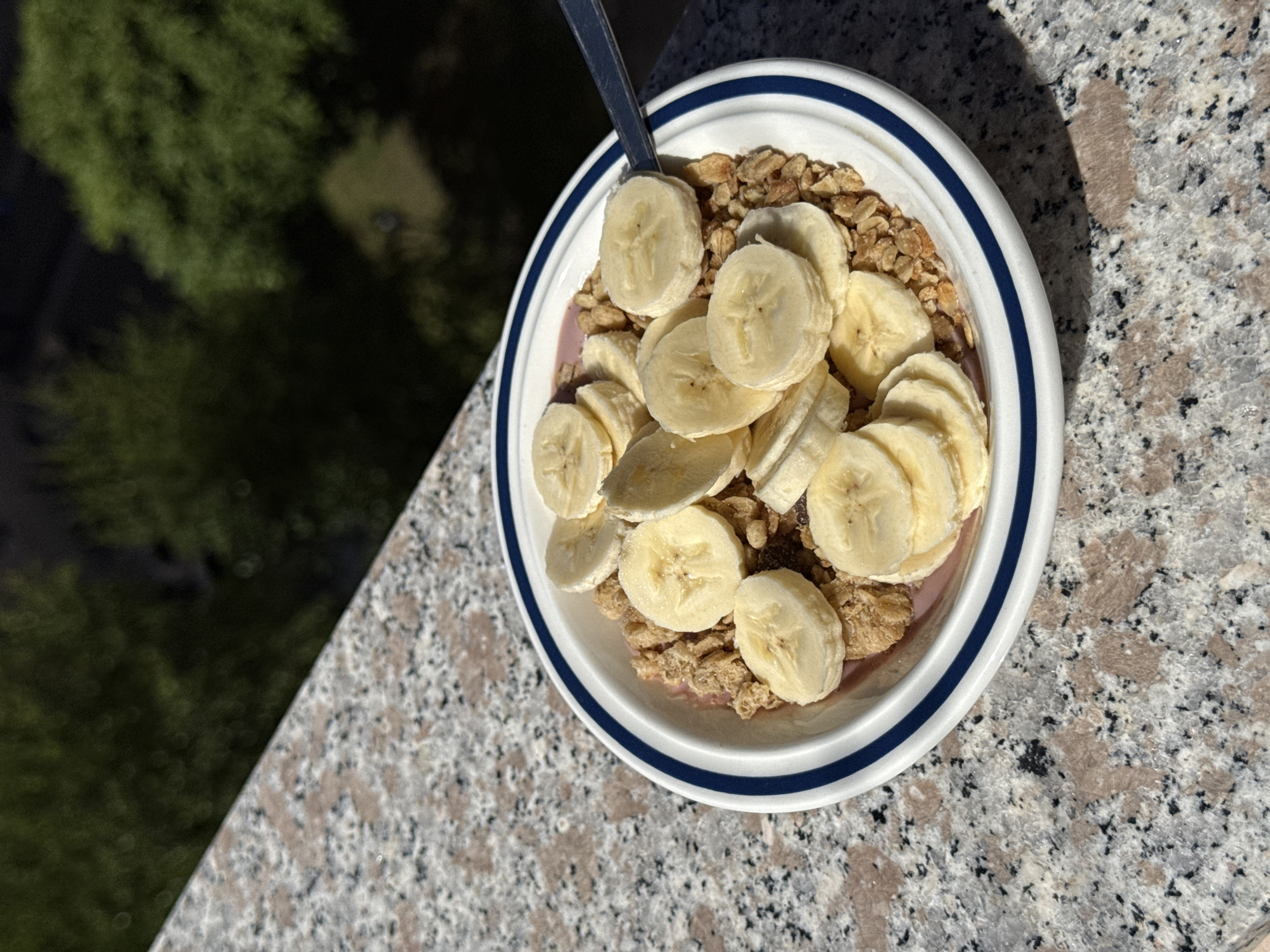 Breakfast bowl photographed on outdoor granite surface in Milan