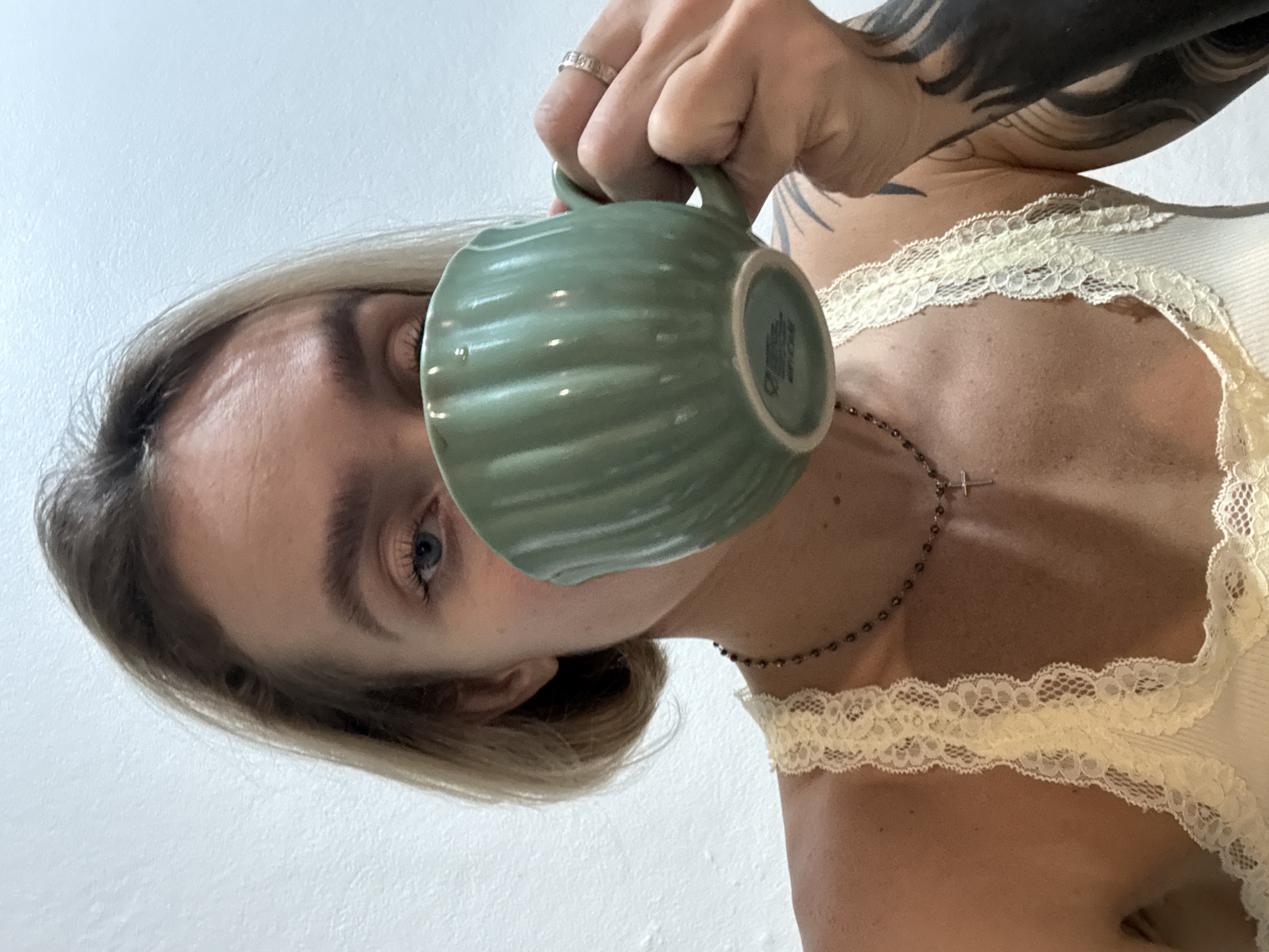 Woman drinks from green mug in Karon, Thailand