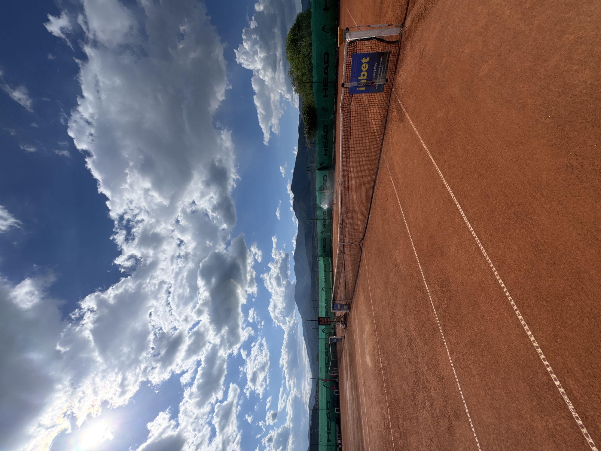 On a red clay court in Velingrad, racket in hand.