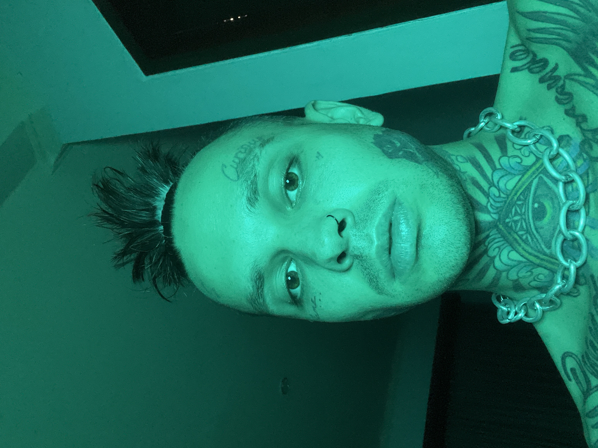 Tattooed selfie series under moody teal and green lighting