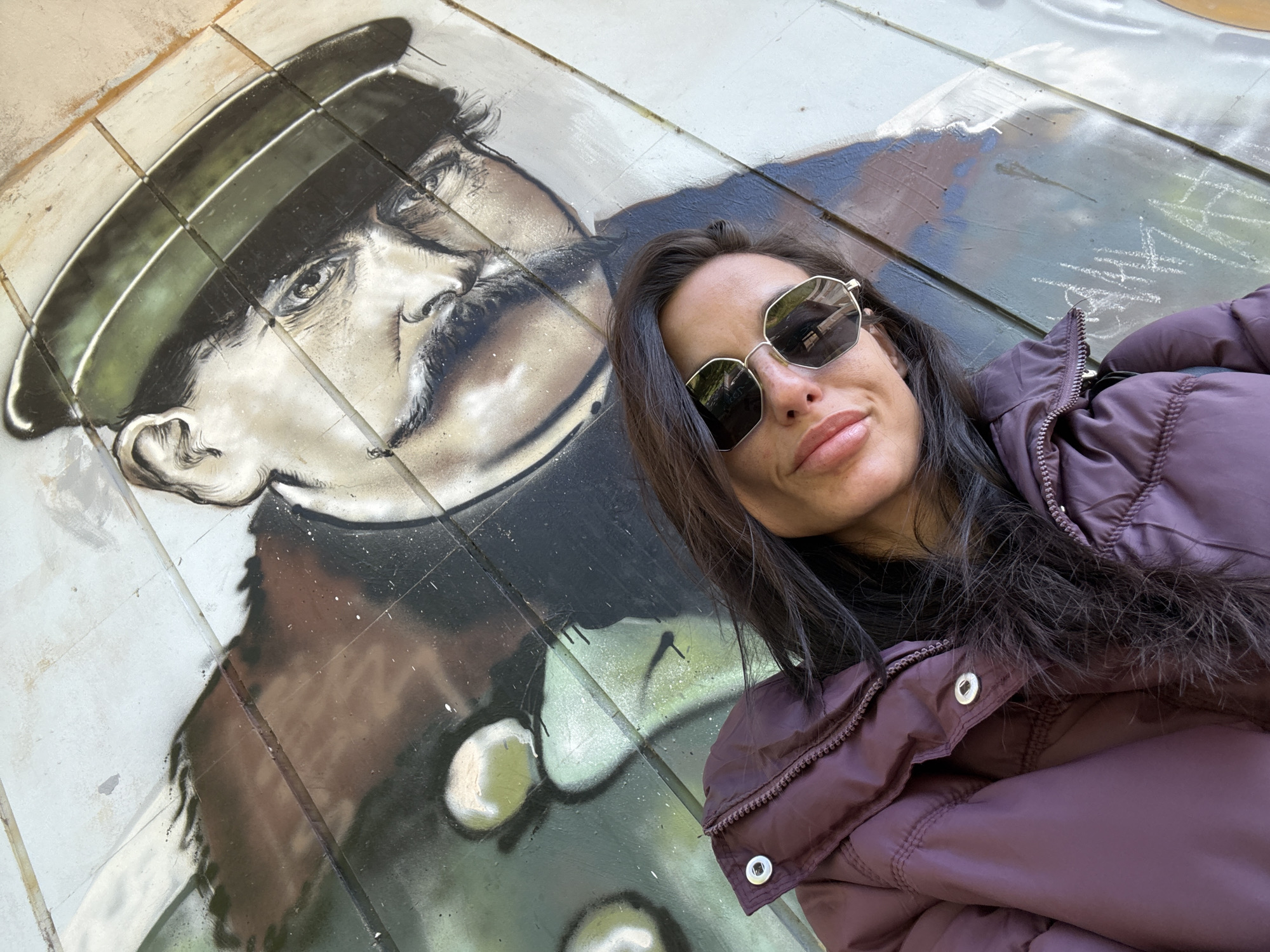 Woman photographs morning walk near historical murals in Pleven