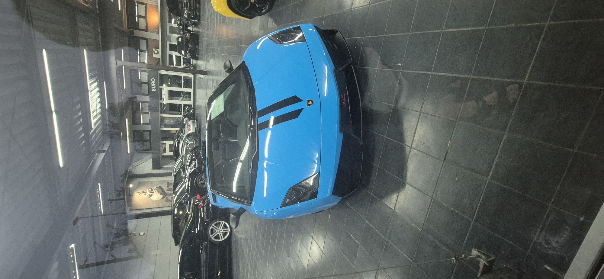 Exotic cars on a showroom floor, Mainz at dusk
