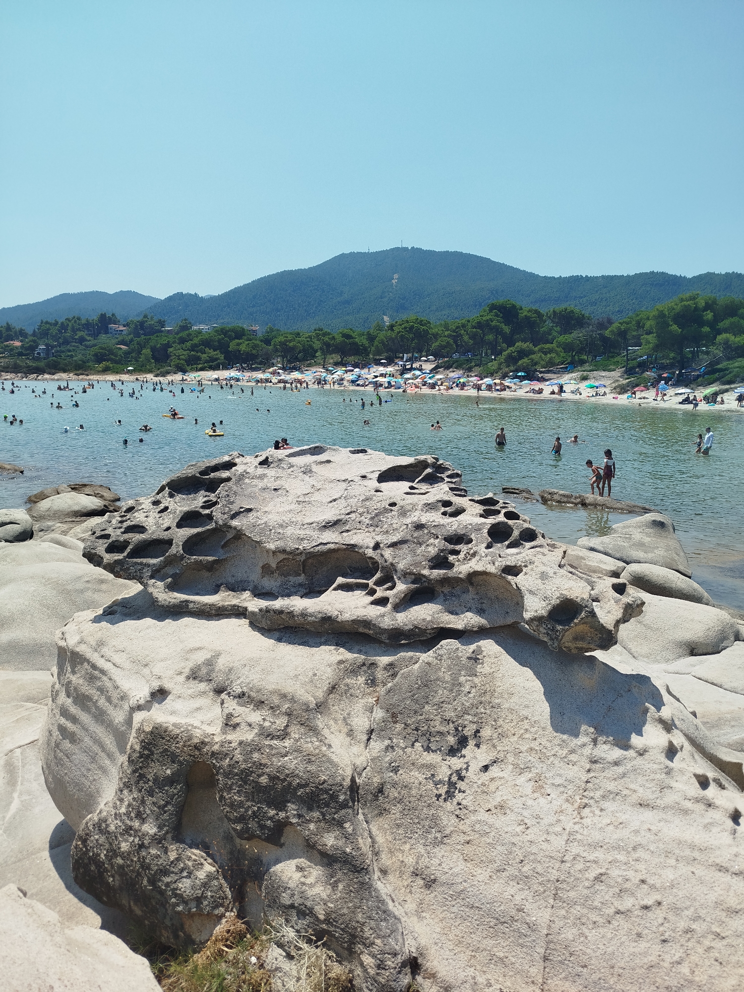 Sithonia's rocky shoreline on a busy summer morning