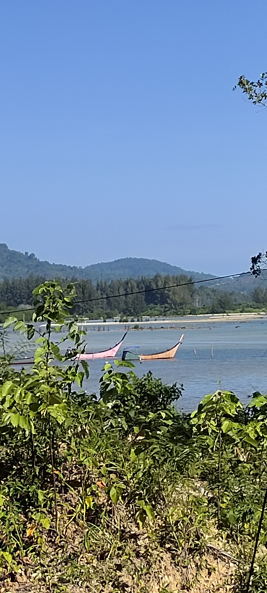 Traditional fishing boats and wooden platform on calm Indonesian coast