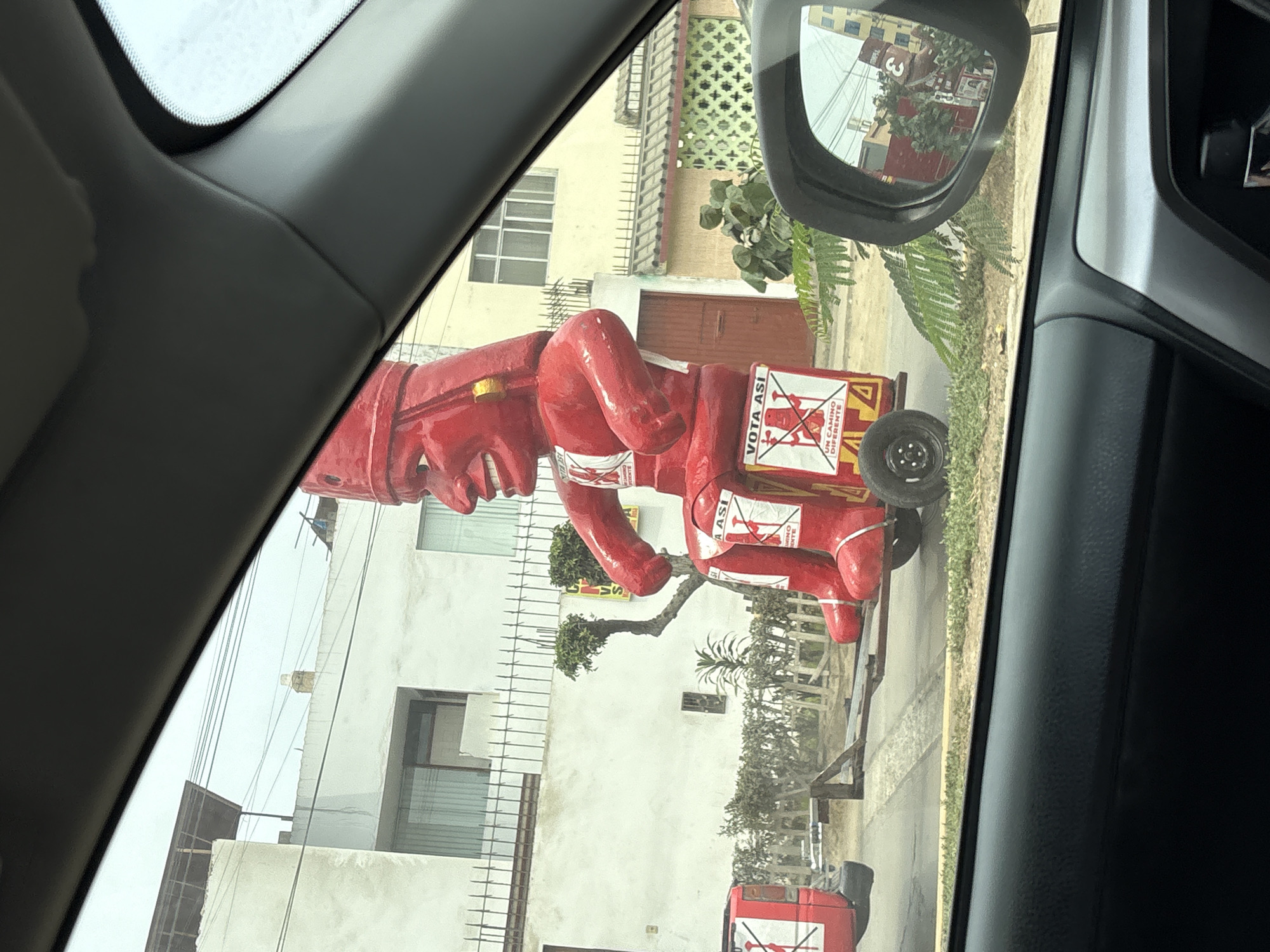 Political parade features red cartoon figure in La Perla Peru