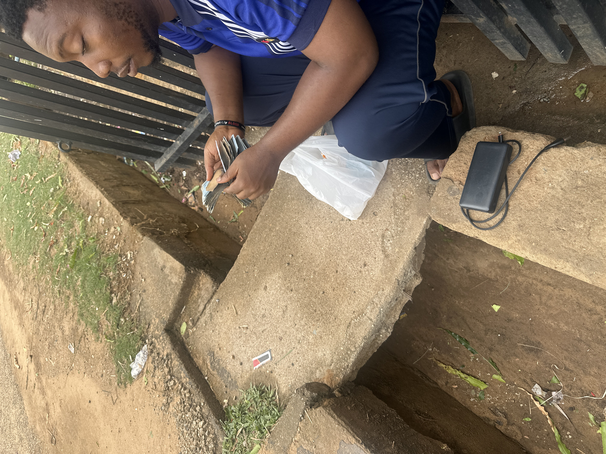Man counts money outdoors in Barden Yana, Nigeria