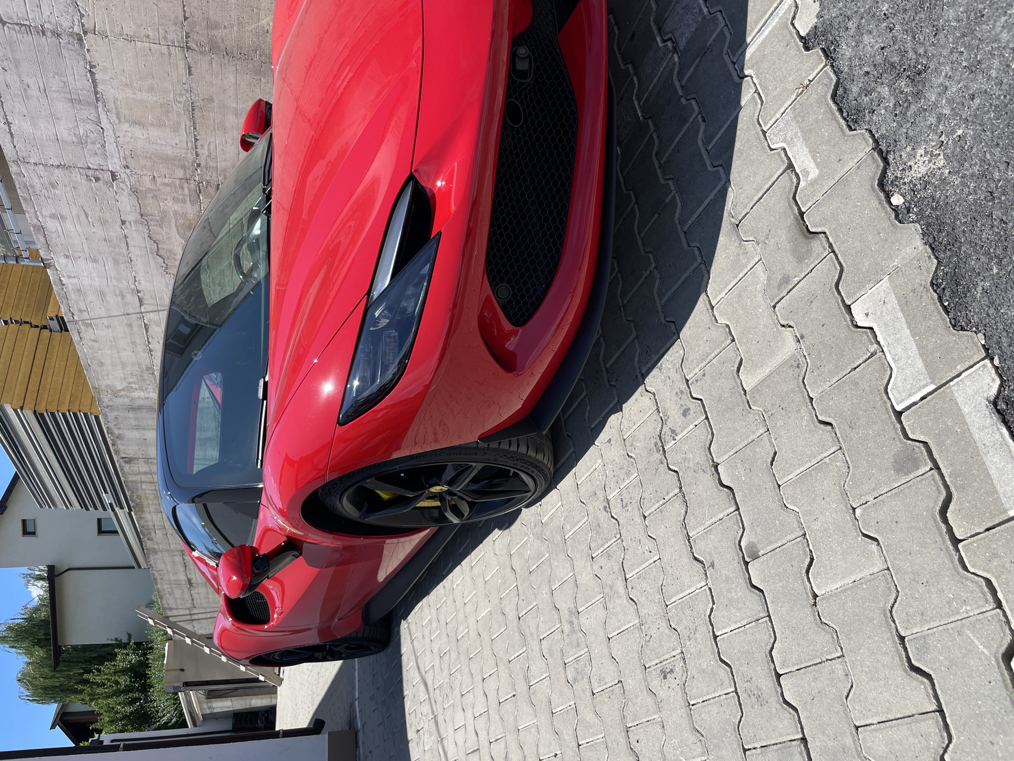 Red Ferrari parked outside, shot from two angles