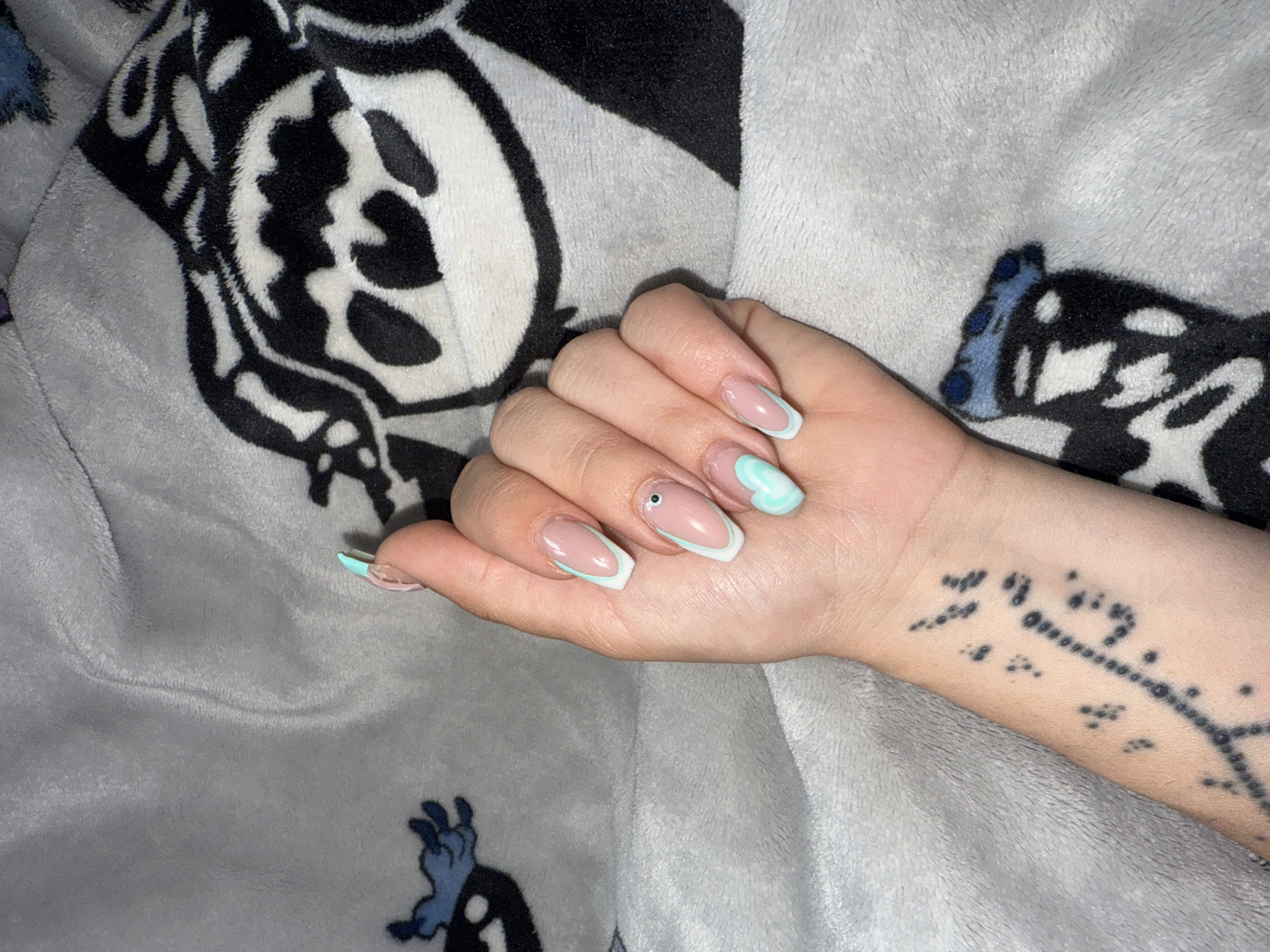 Hand with French manicure rests on Stitch blanket in Bulgaria