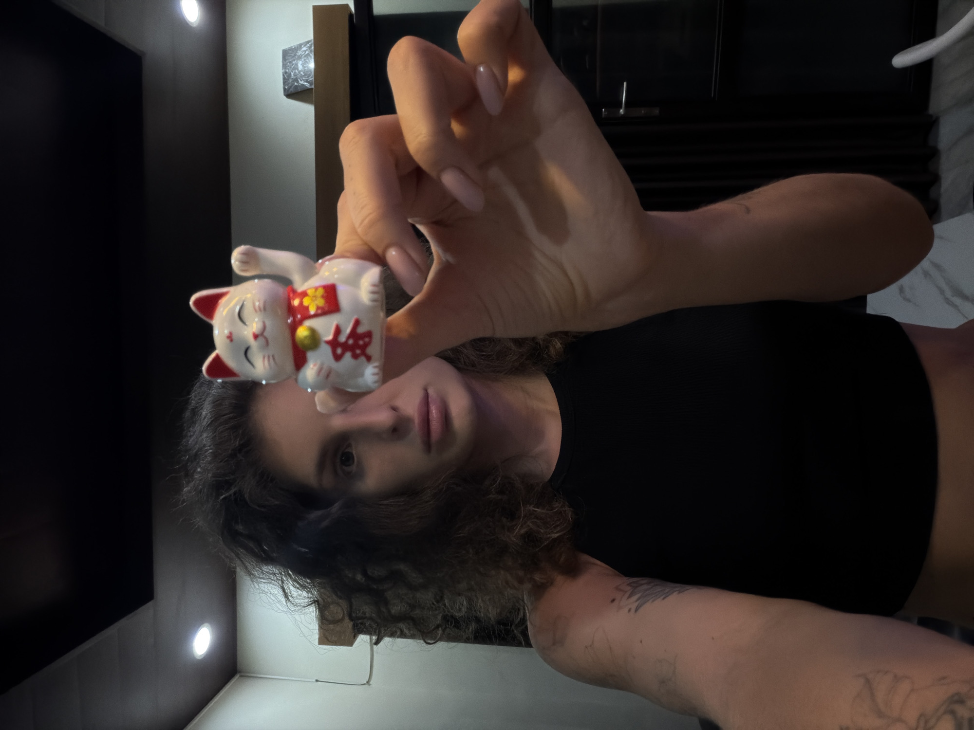 Person displays lucky cat figurine in North Kuta