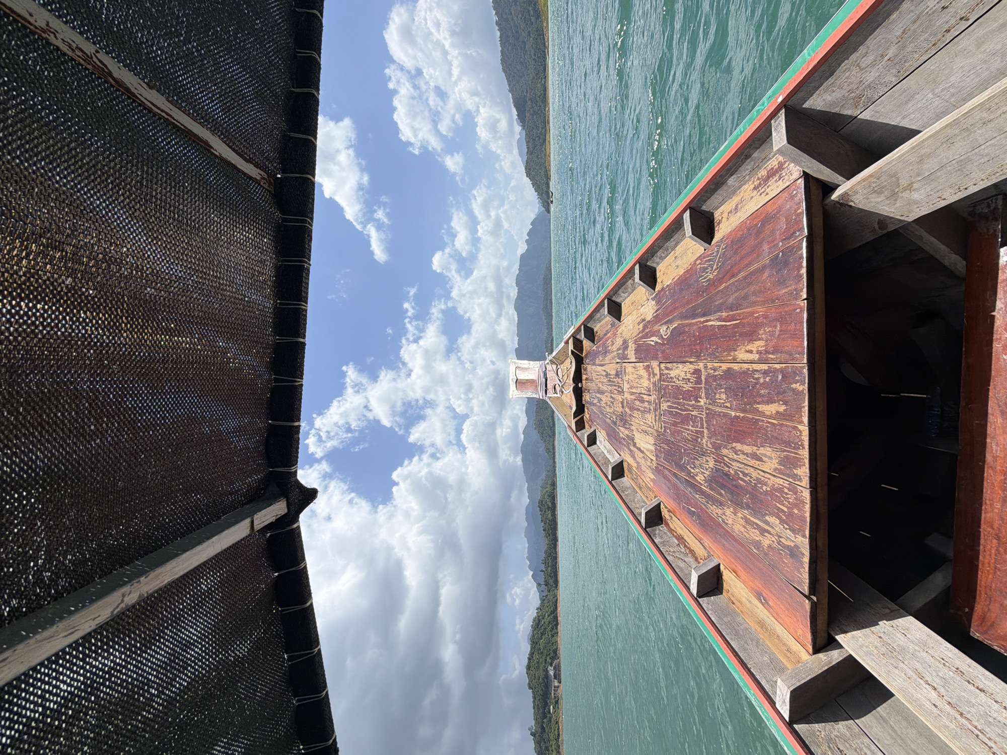 Longtail boat gliding across Cheow Lan Lake, Thailand