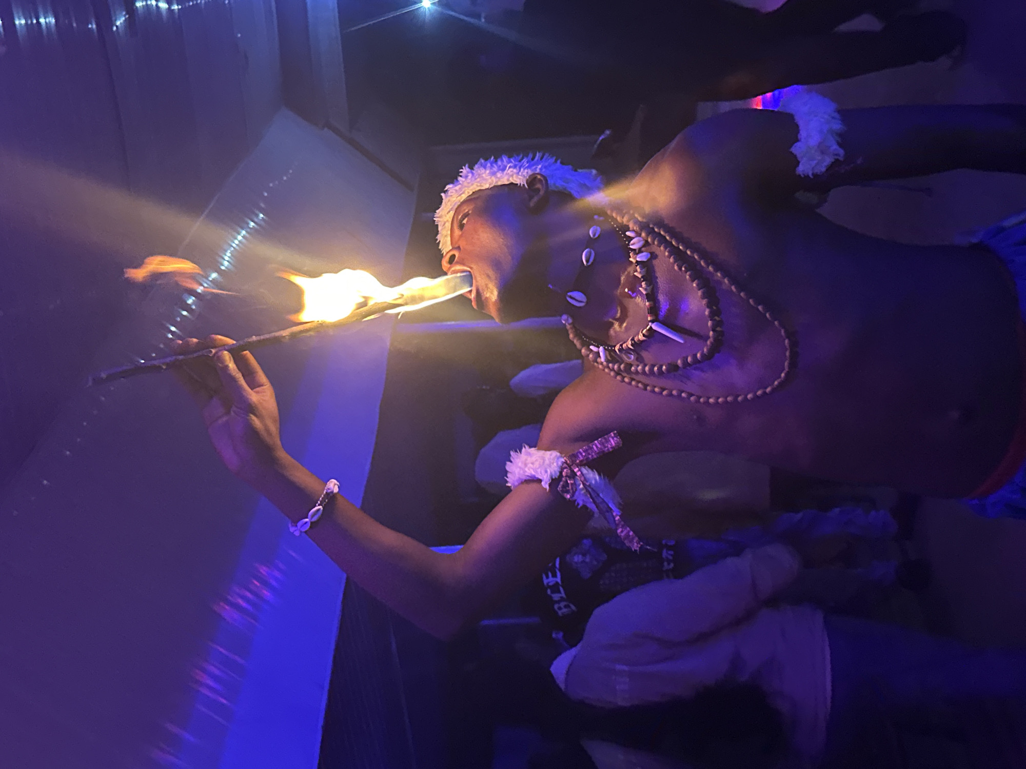 Late-night fire performance and dancing at a Wumat venue