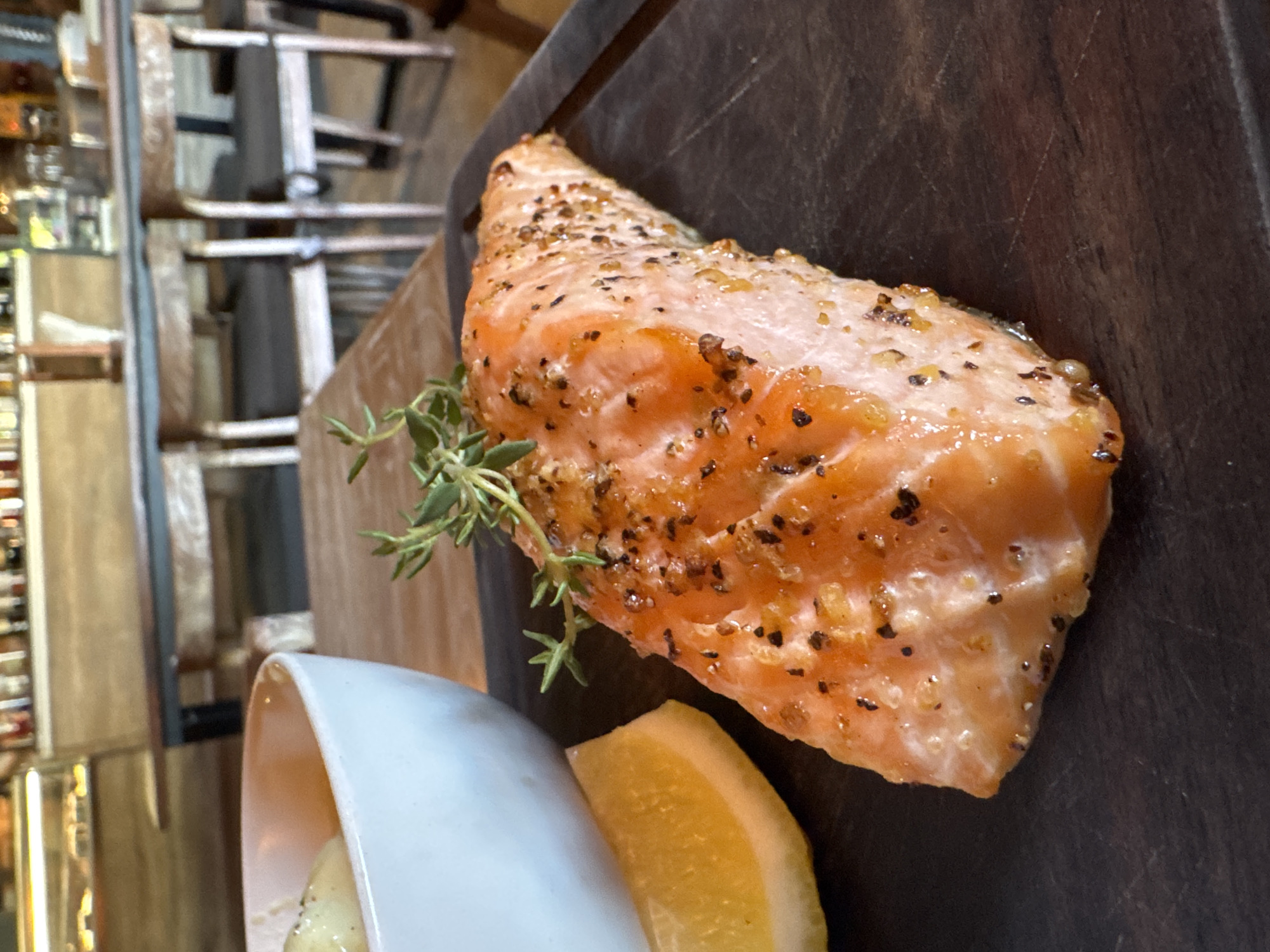 Diner documents salmon meal at Kuta restaurant