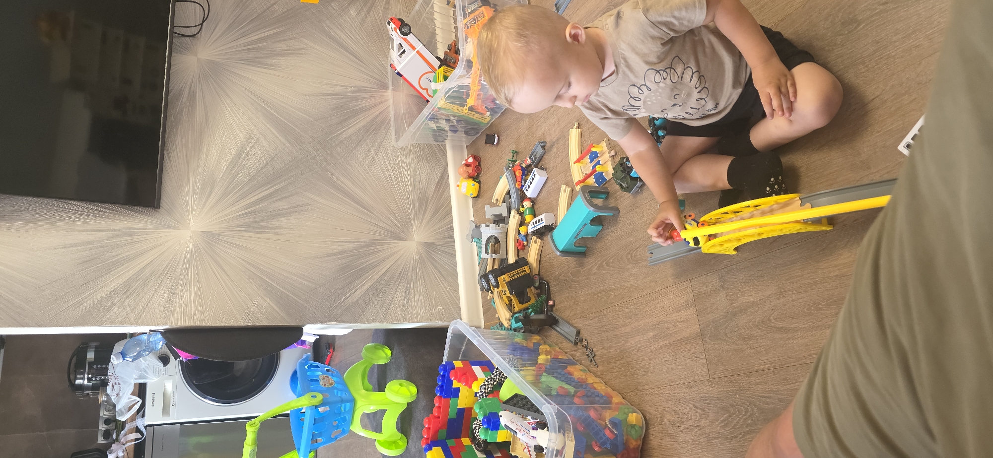 Playroom scene in Berdsk with toy train track and organized bins